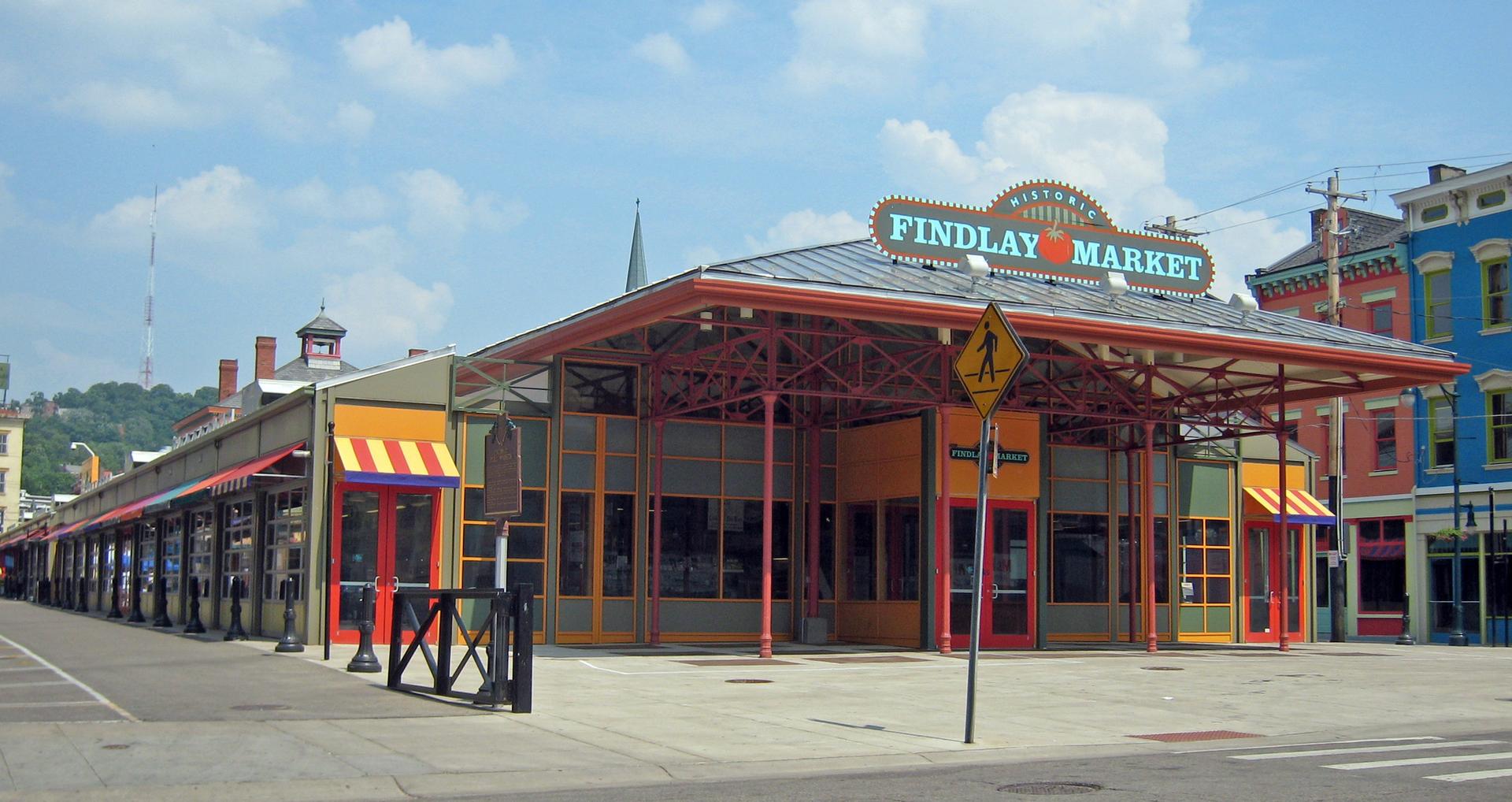 Colorful market building with awnings on a sunny urban street.