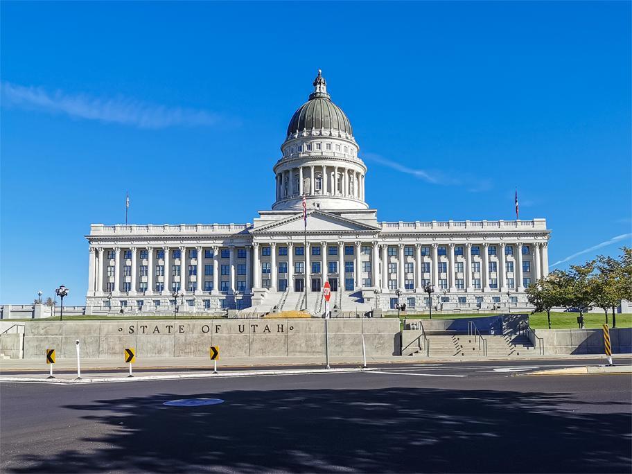 Grand white building with a large dome under a clear blue sky.