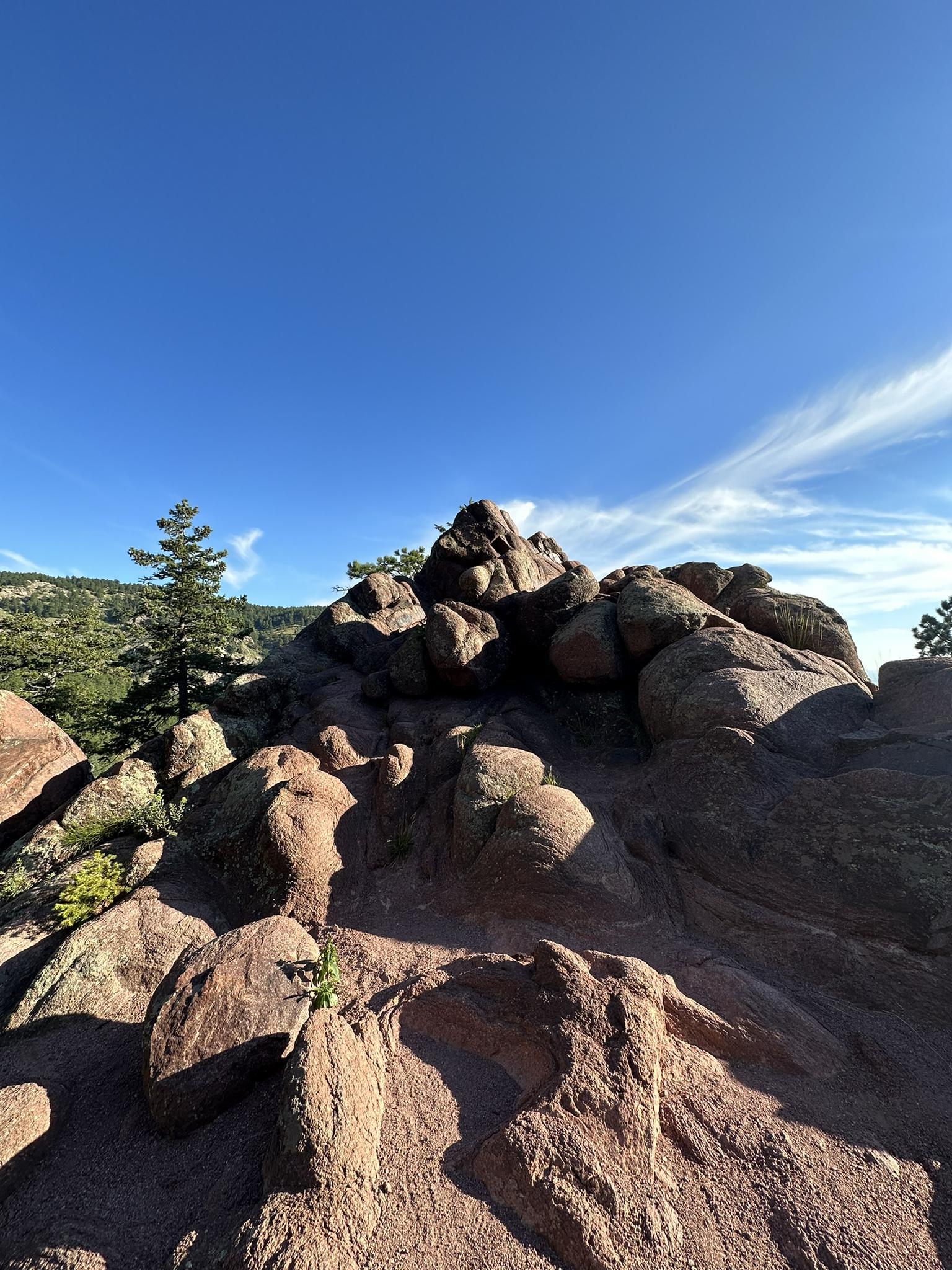 Large red rock formation on a sunny day with a clear blue sky.