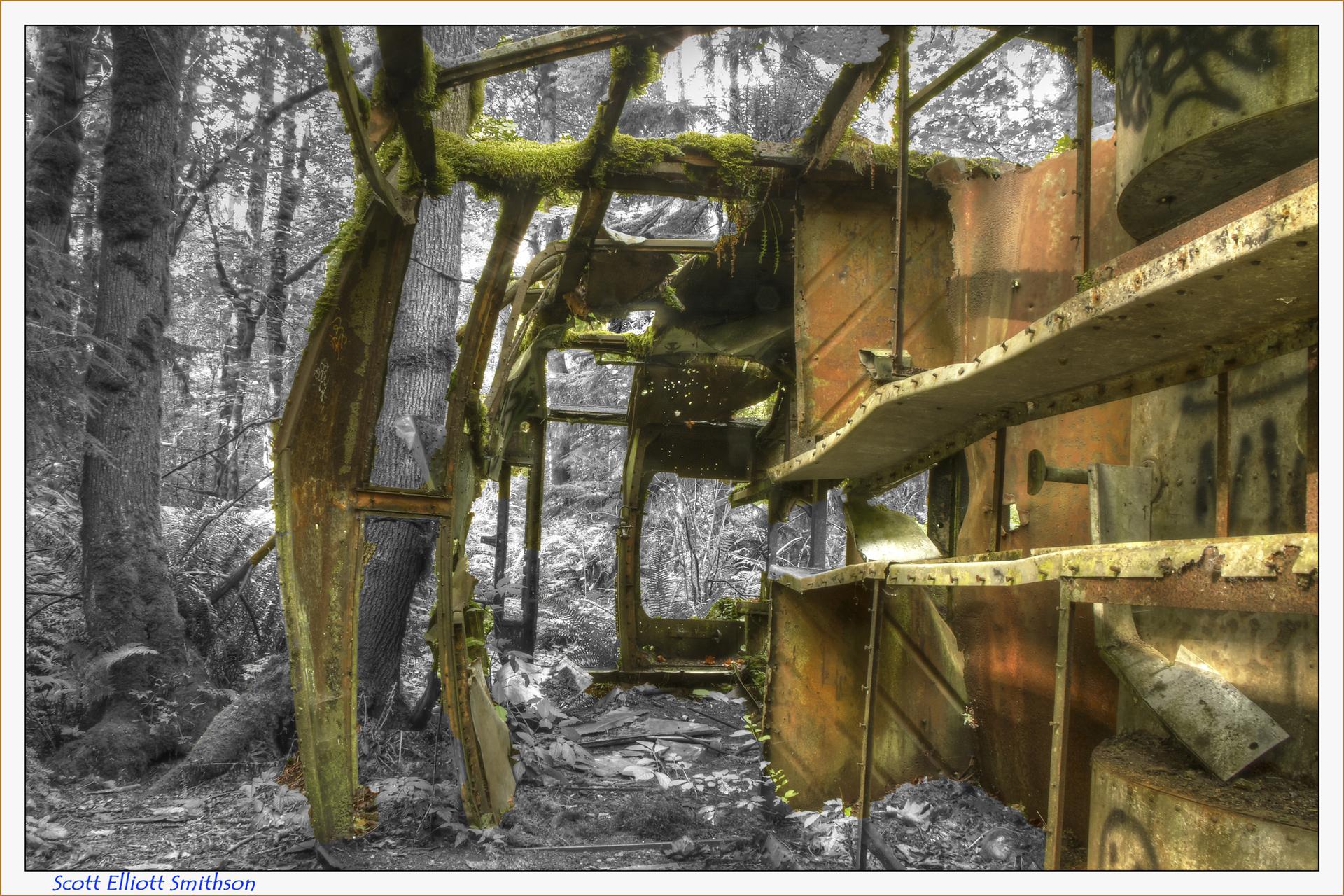 Moss-covered, rusted metal structure abandoned in a dark, dense forest.