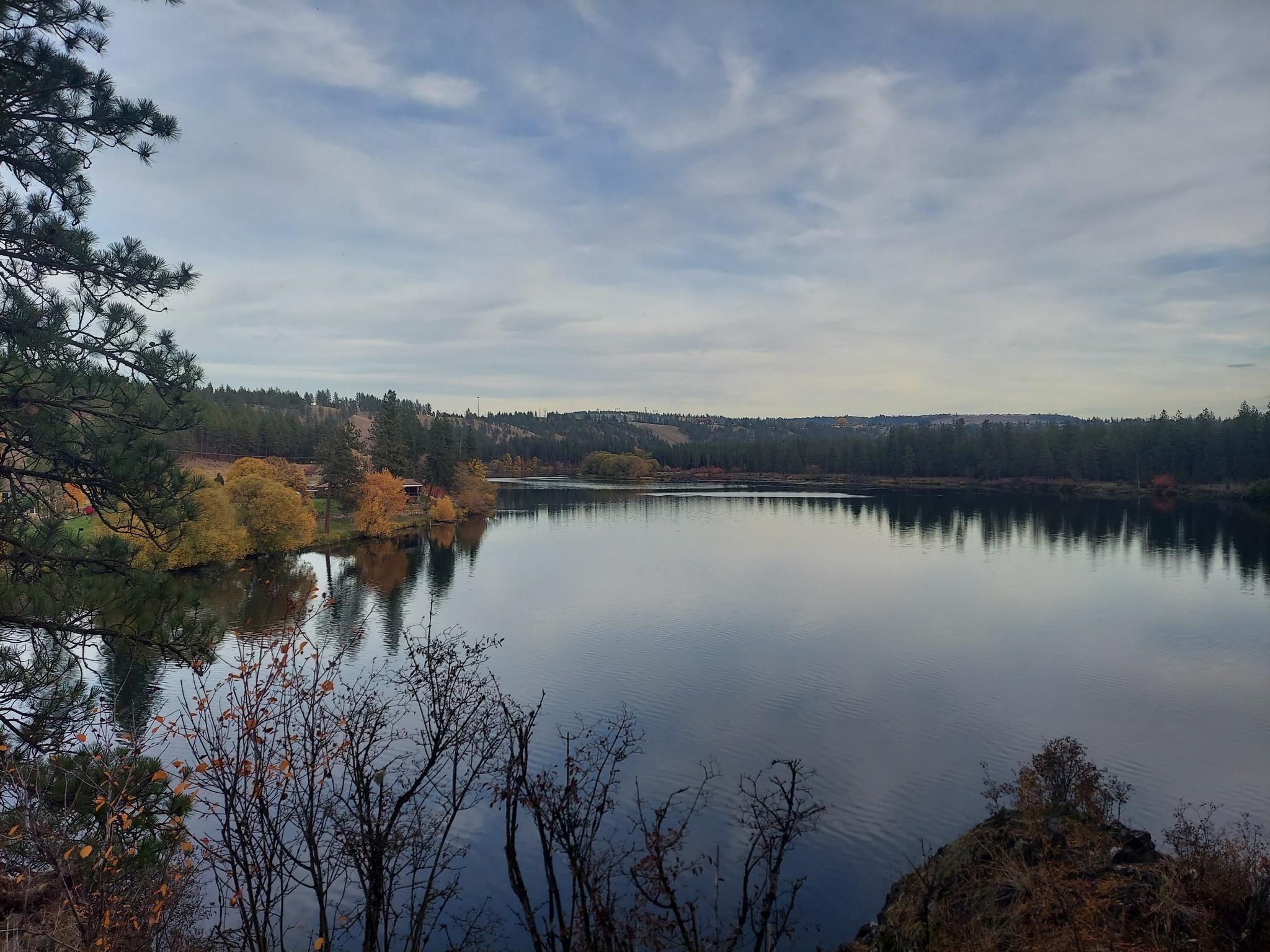 A calm lake surrounded by autumn trees under an overcast sky. - Riverside State Park Loop via Centennial Trail and Trail 25