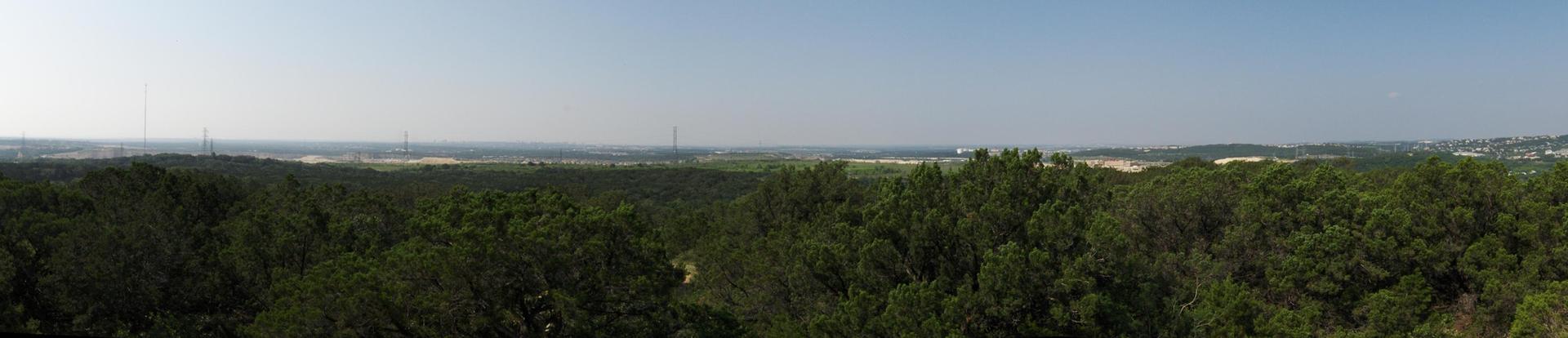 A panoramic view of a vast green forest stretching to the horizon.