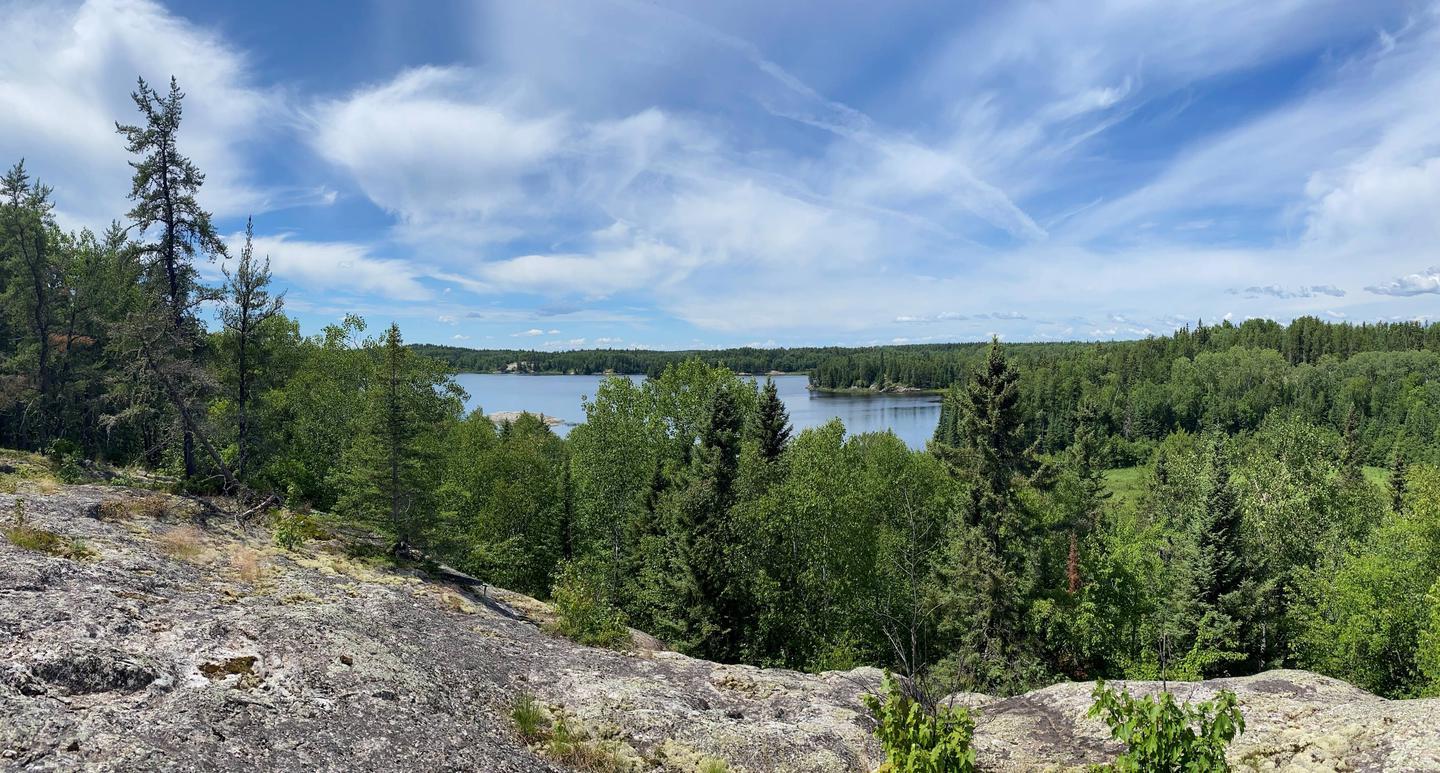 Panoramic view of a large lake surrounded by lush green forest.