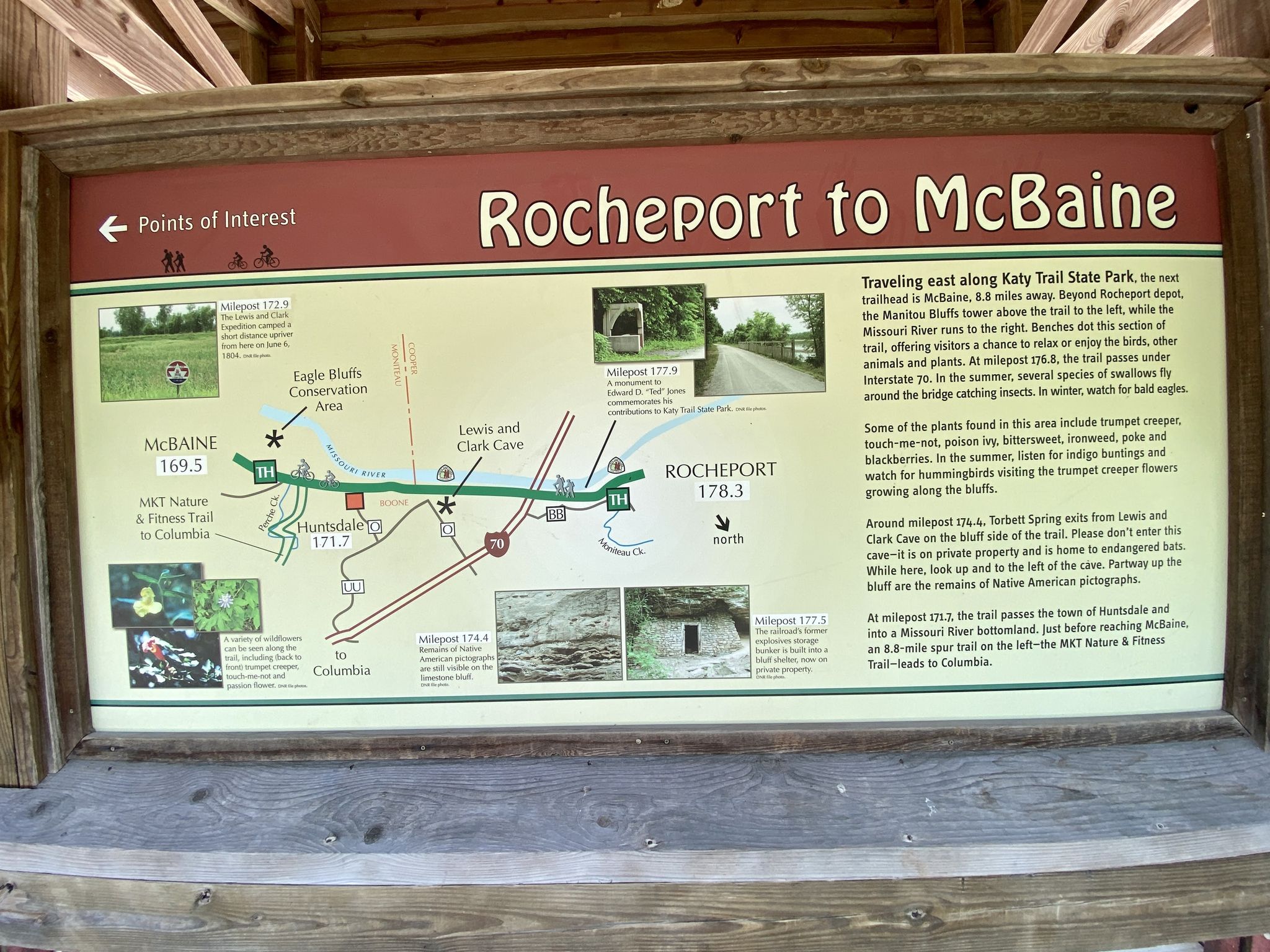 An outdoor information sign with a map and text under a wooden shelter. - Katy Trail: Rocheport to Huntsdale