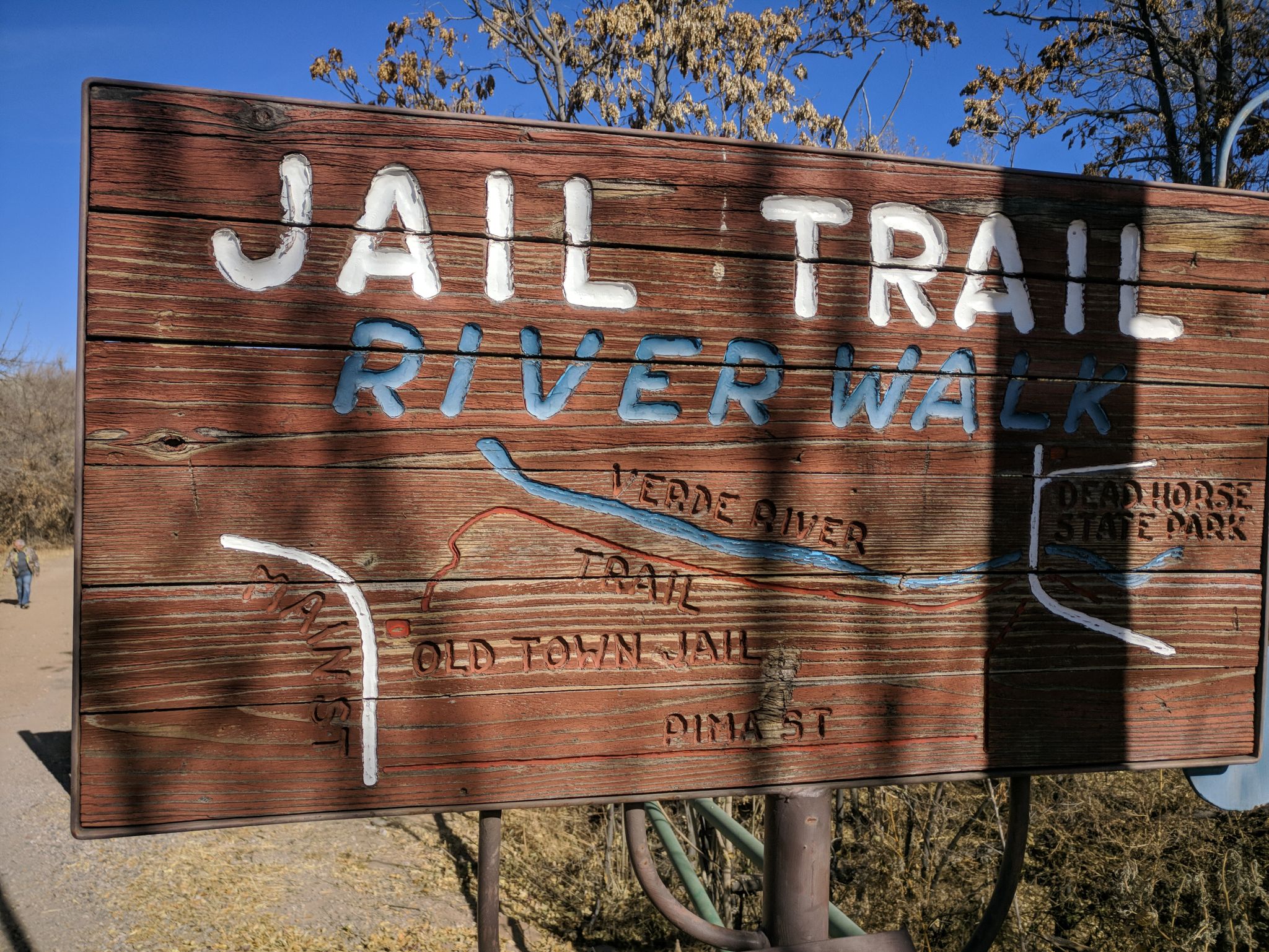 A wooden sign with painted text and a map stands under bright sun. - Cottonwood loop from Cottonwood