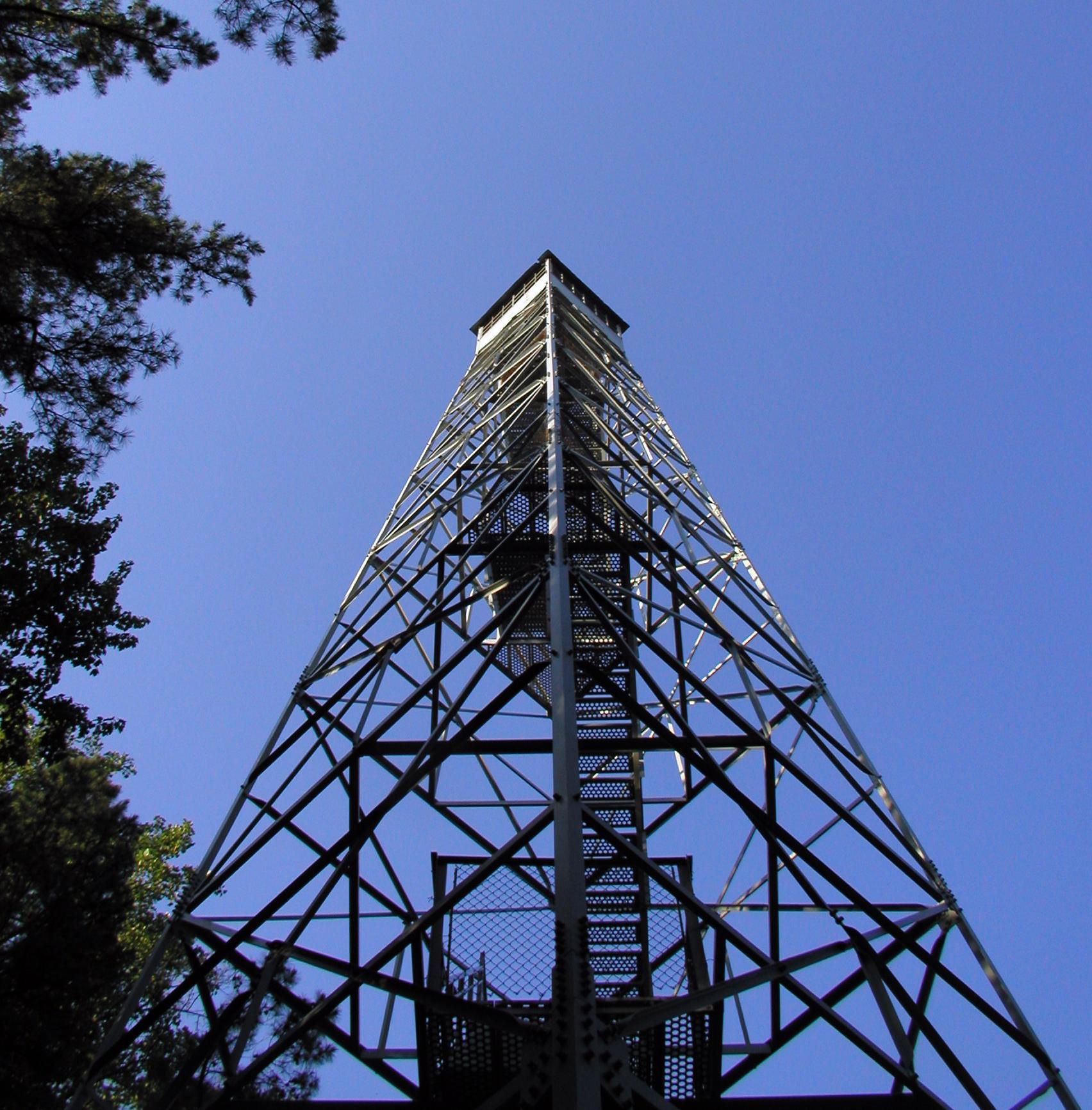 A tall metal observation tower against a clear blue sky.