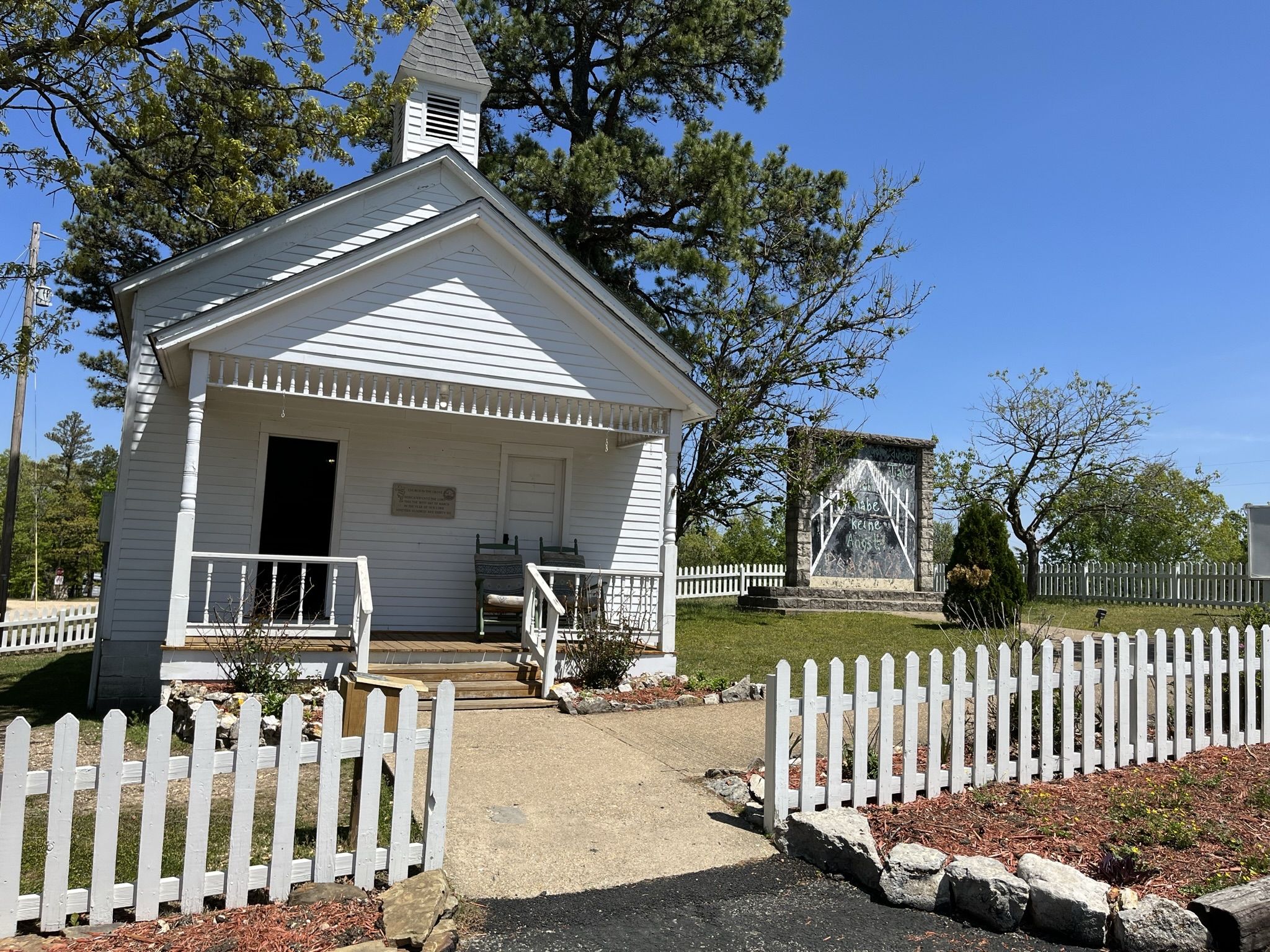 A small white church with a steeple and picket fence on a sunny day. - Passion Play XC Green and Blue Loop - Eureka Springs