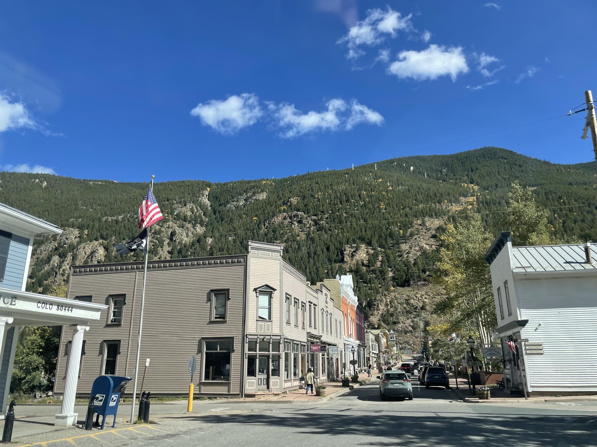 Quaint town street with historic buildings and a large mountain backdrop.