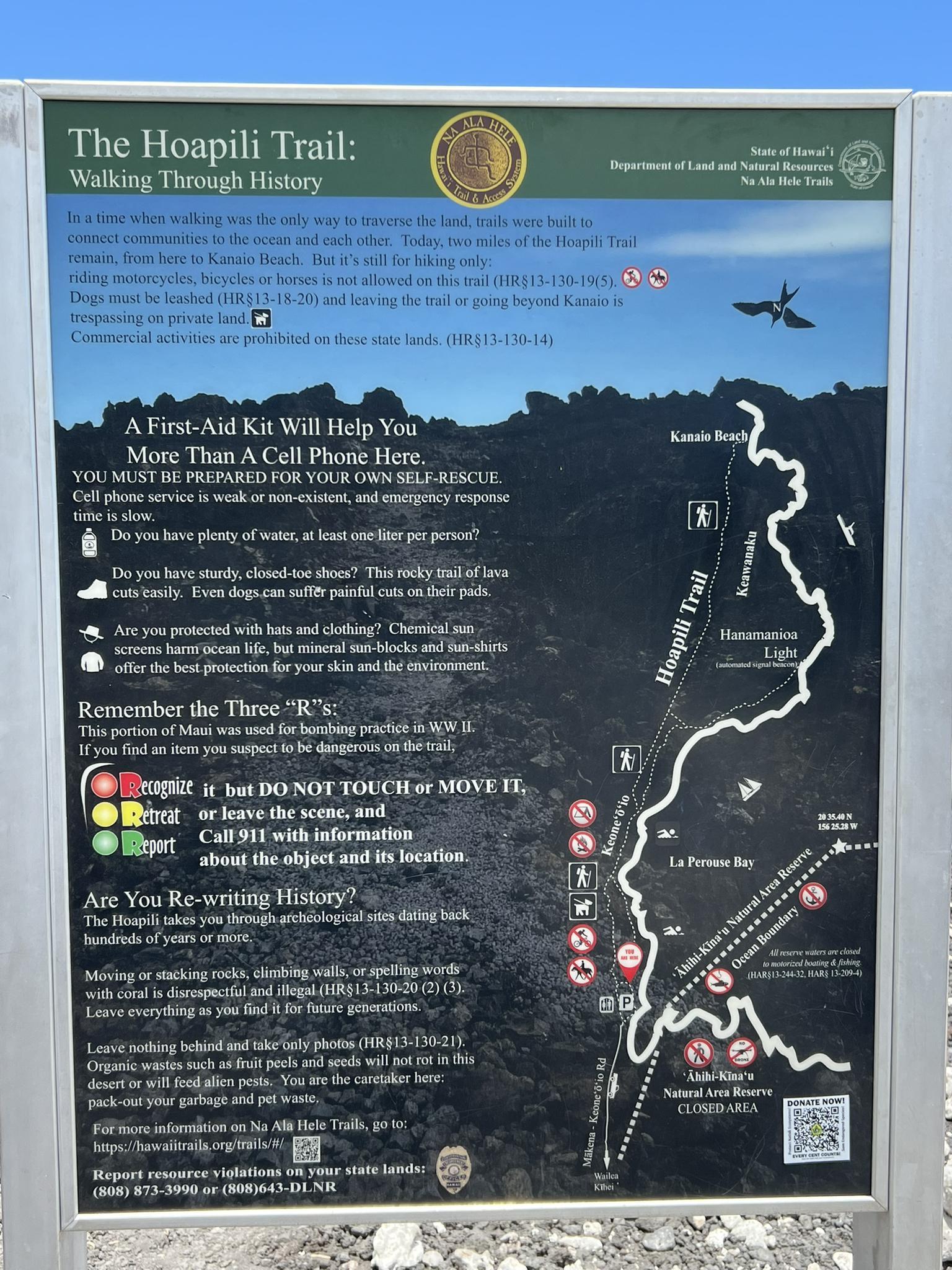 A large informational sign with text and a map under a bright sky.