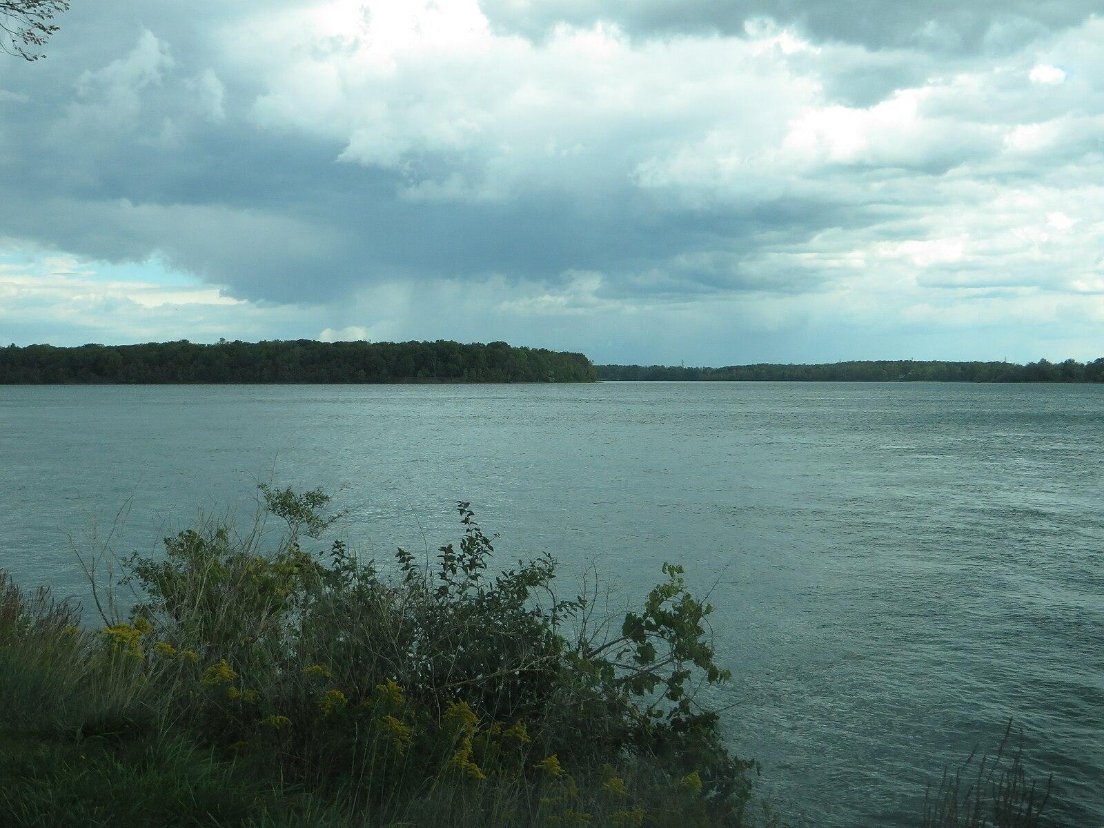 Wide expanse of dark water under a dramatic, cloudy sky.