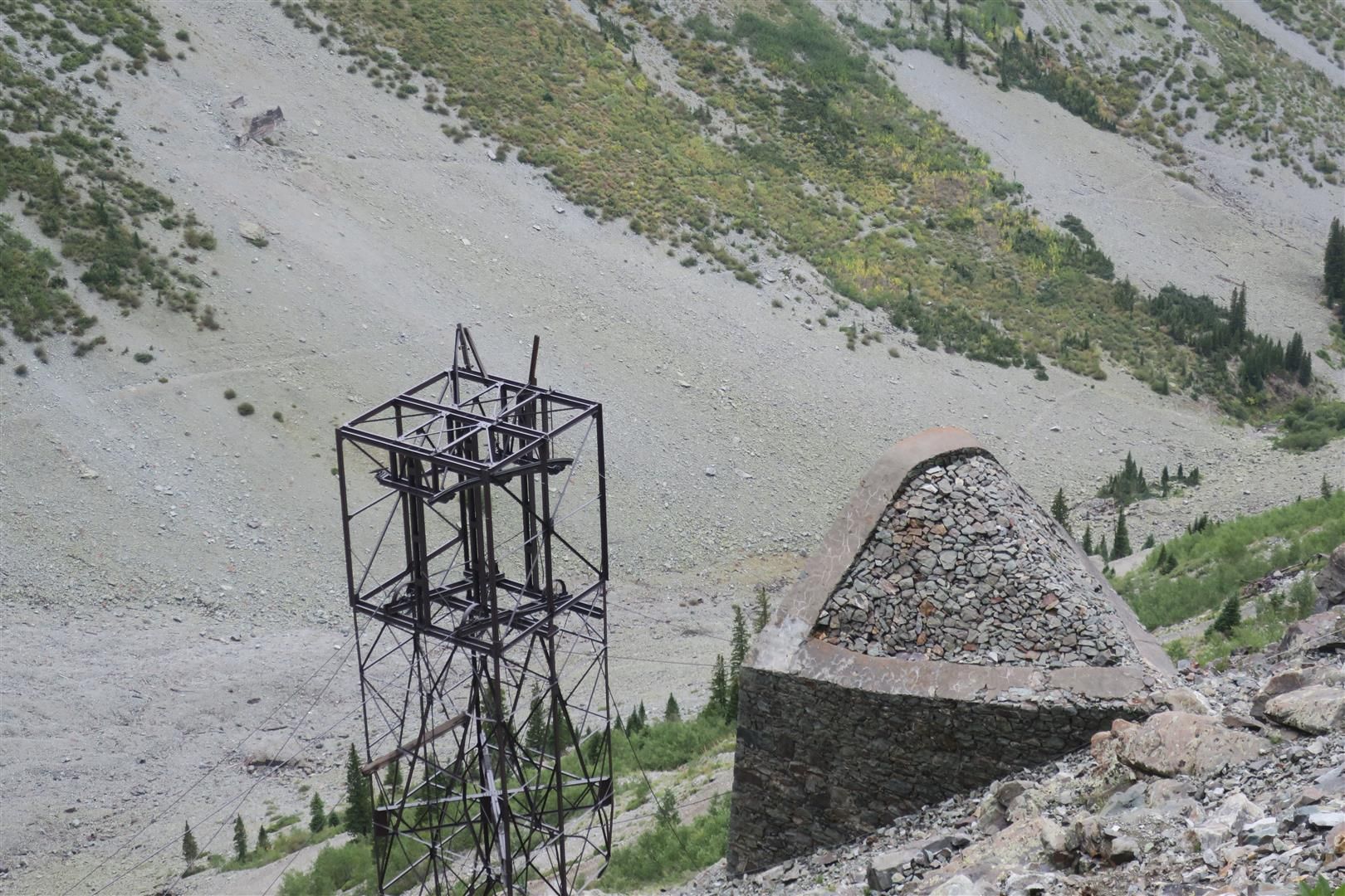 Metal structure and stone mound on a steep, rocky mountain slope. - Silver Lake Trail