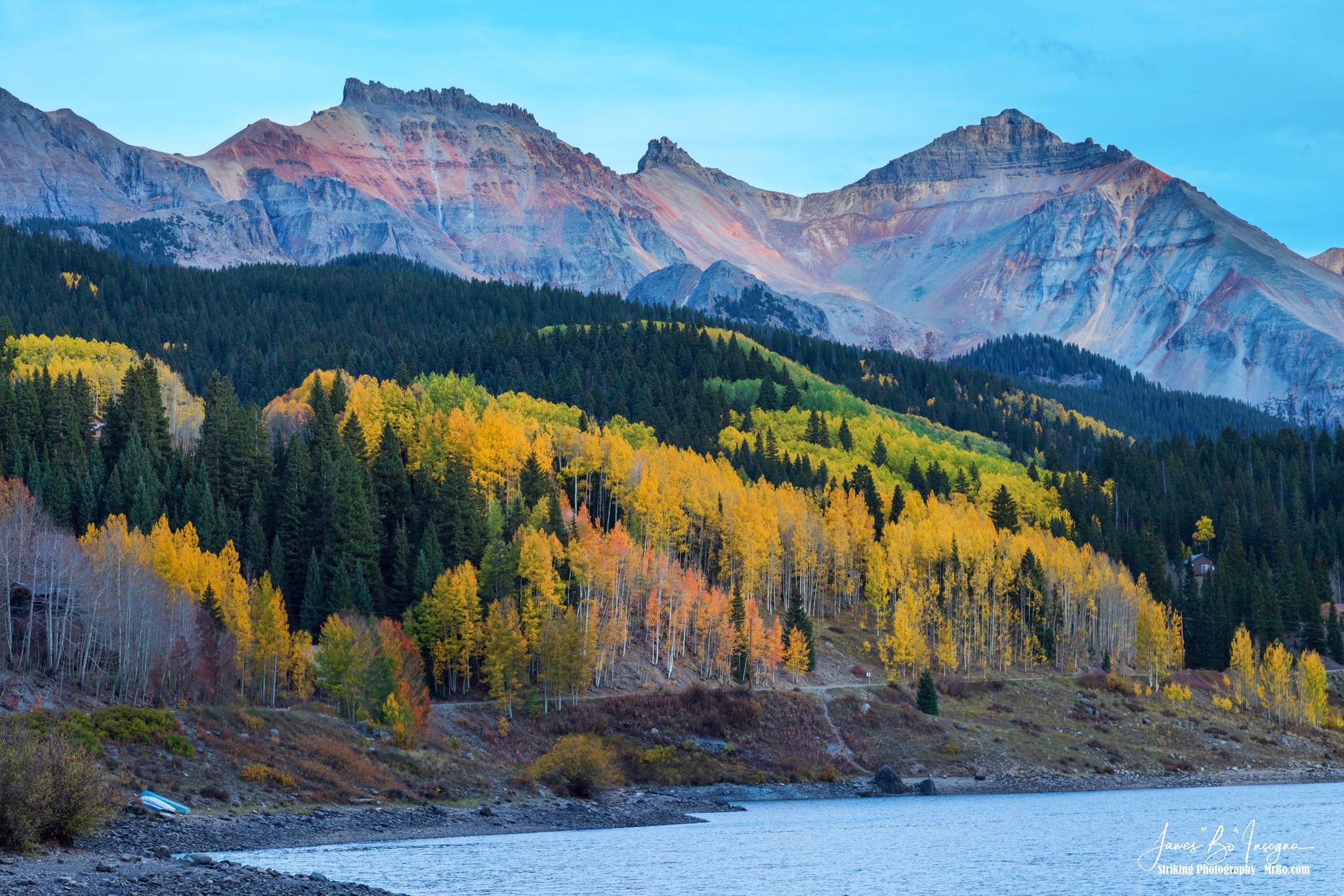 Majestic mountains overlook a lake and vibrant autumn forests under clear skies. - Trout Lake via Priest Lake Trail