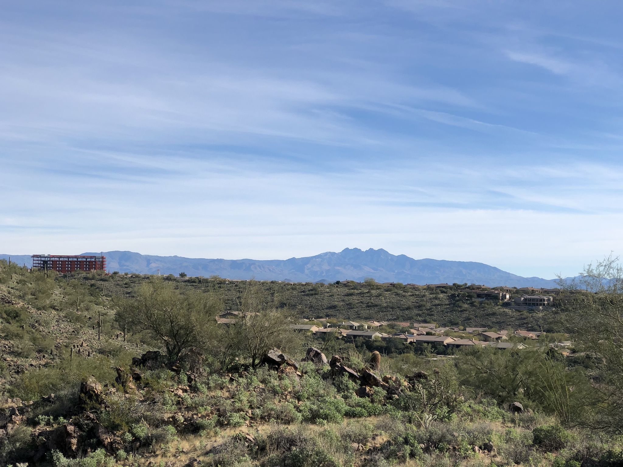 Vast desert landscape with distant mountains, sparse vegetation, and a construction site. - Sunrise Trail loop from Andalusia