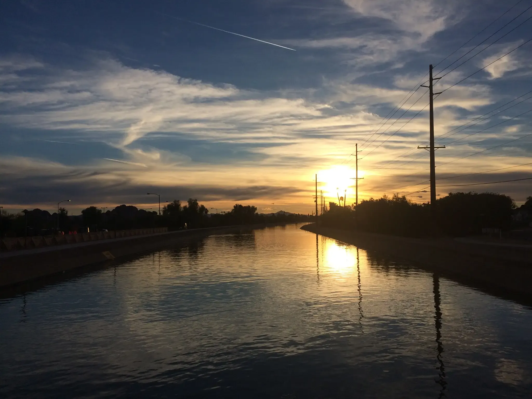 A canal reflects a vibrant sunset sky with silhouetted power lines. - Rio Salado and Crosscut Canal Loop