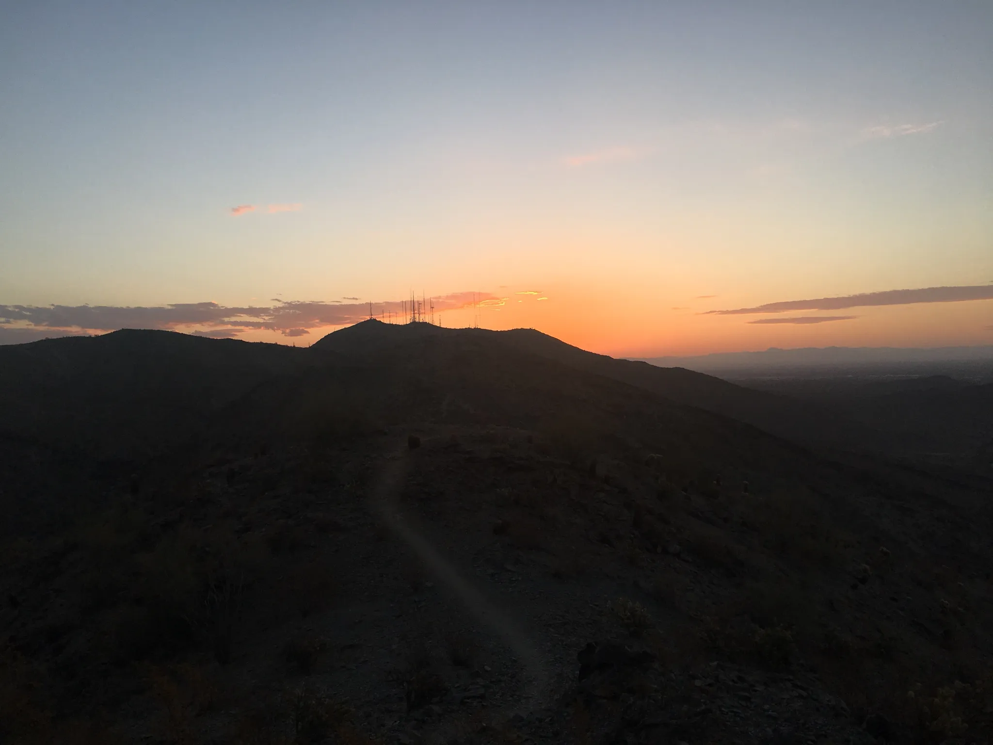 Dark mountain silhouettes against a vibrant orange and blue sunset sky. - Goat Mountain via Pyramid, National and Lost Ranch Mine Loop
