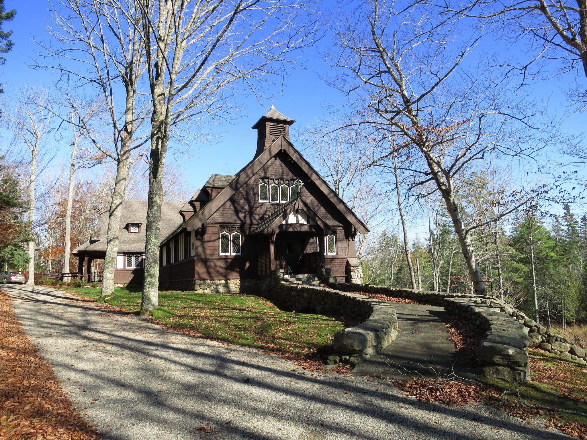 Dark wooden church with stone wall on a sunny autumn day. - Isleboro Island, Maine south loop
