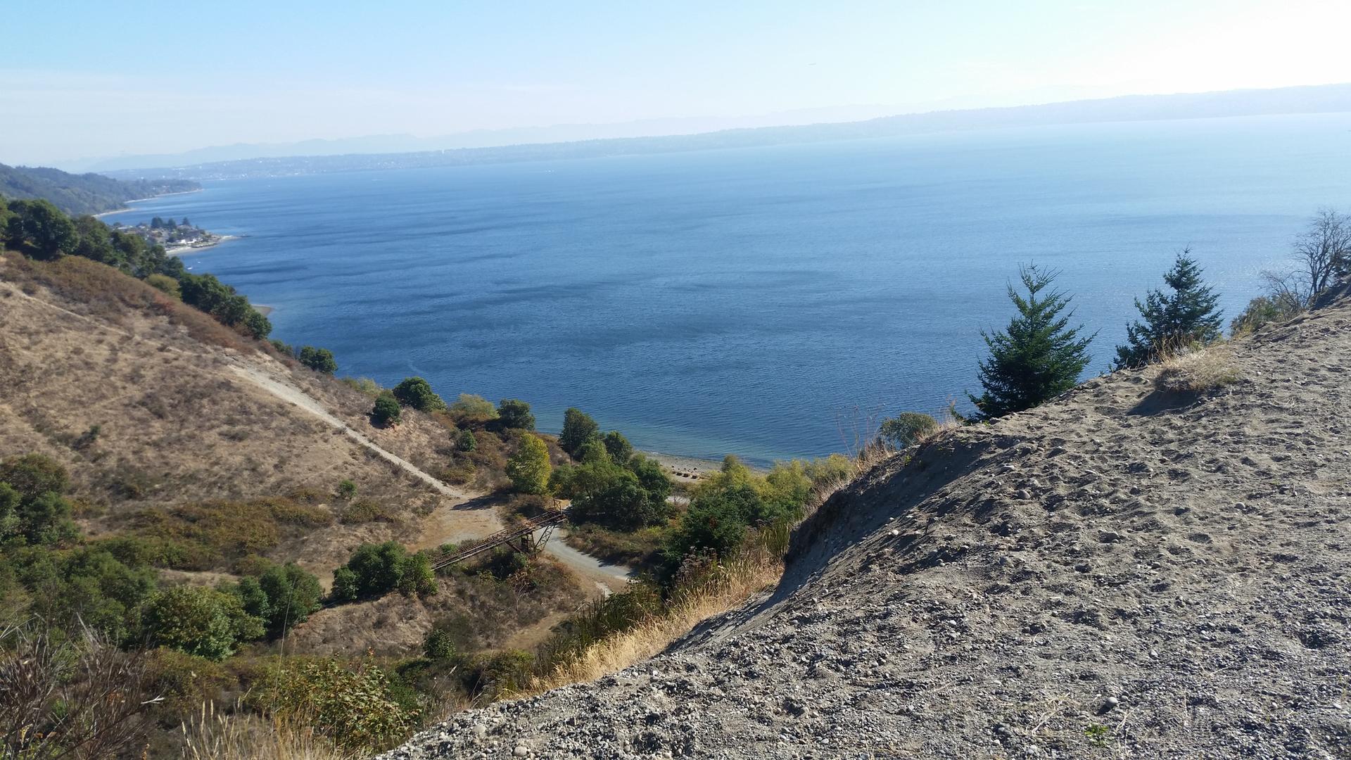Expansive view of a deep blue body of water from a dry, high hillside.