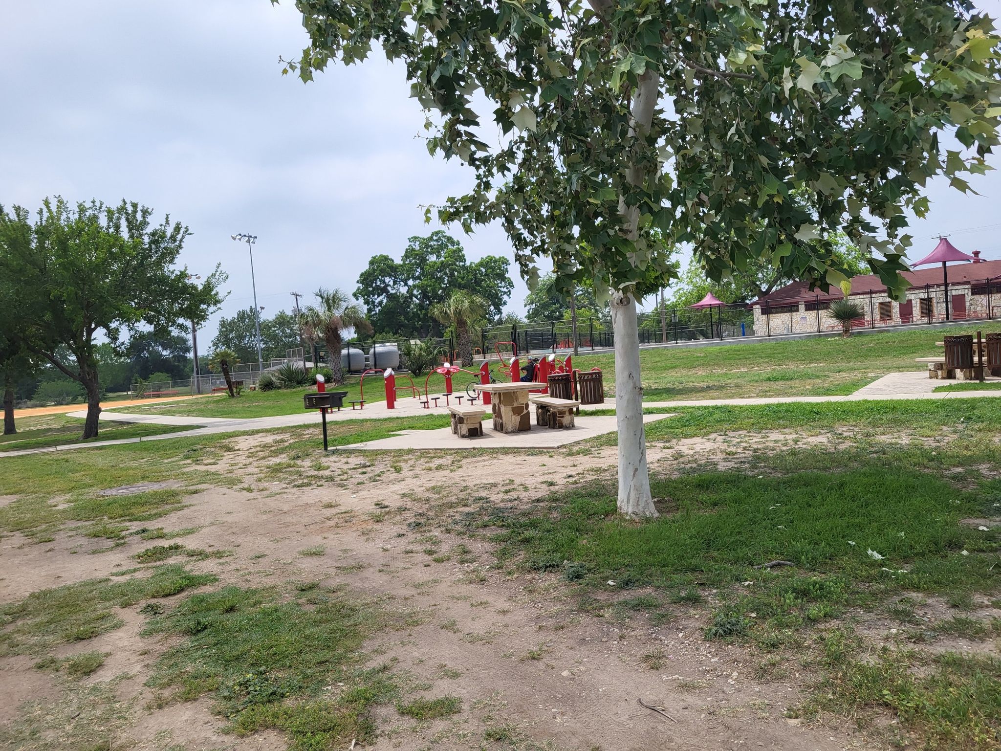 Park with picnic tables and playground equipment under an overcast sky. - San Antonio River View – Concepcion Park loop from Tower of the Americas