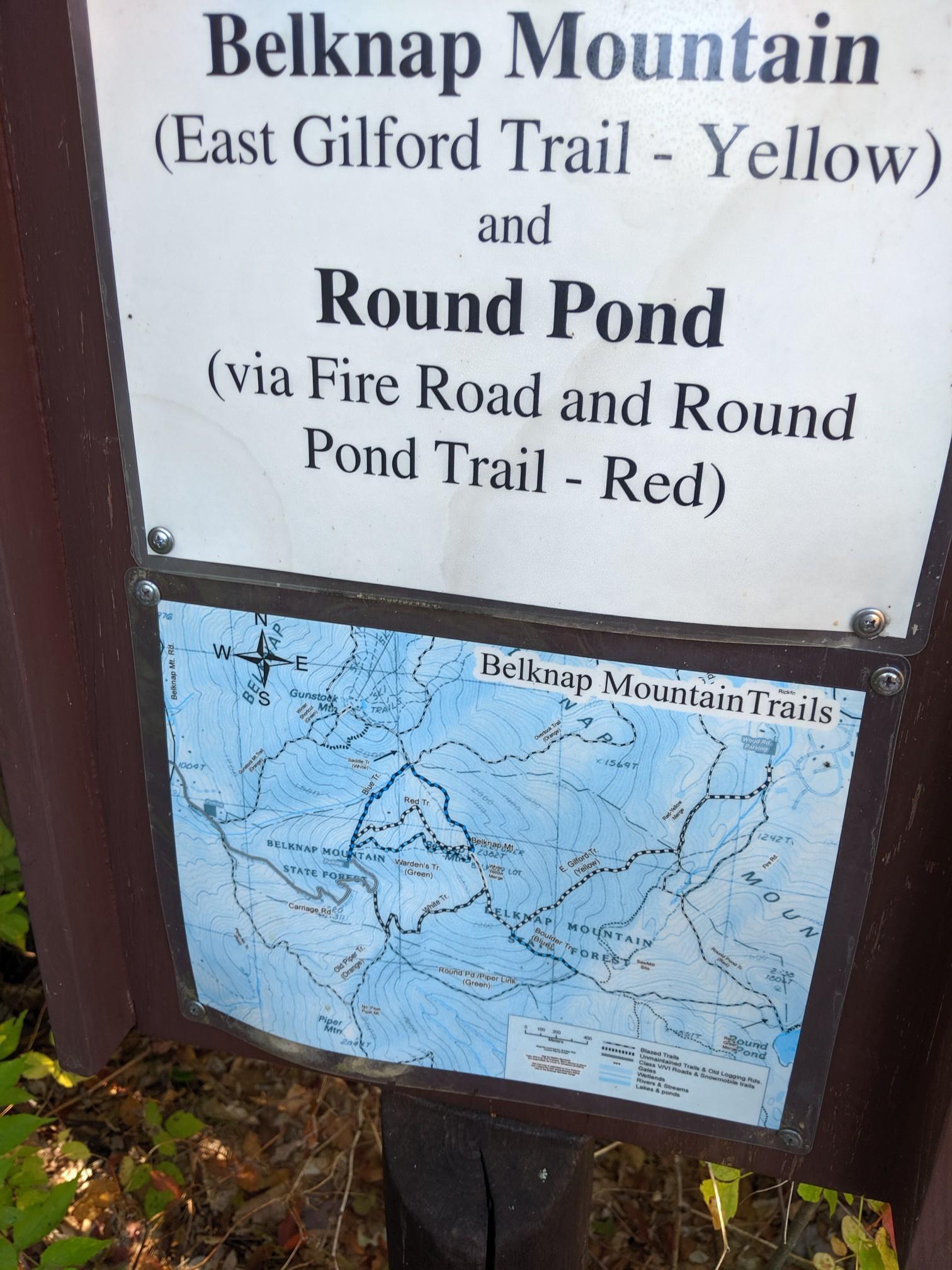 A close-up of a trail sign with text and a map.