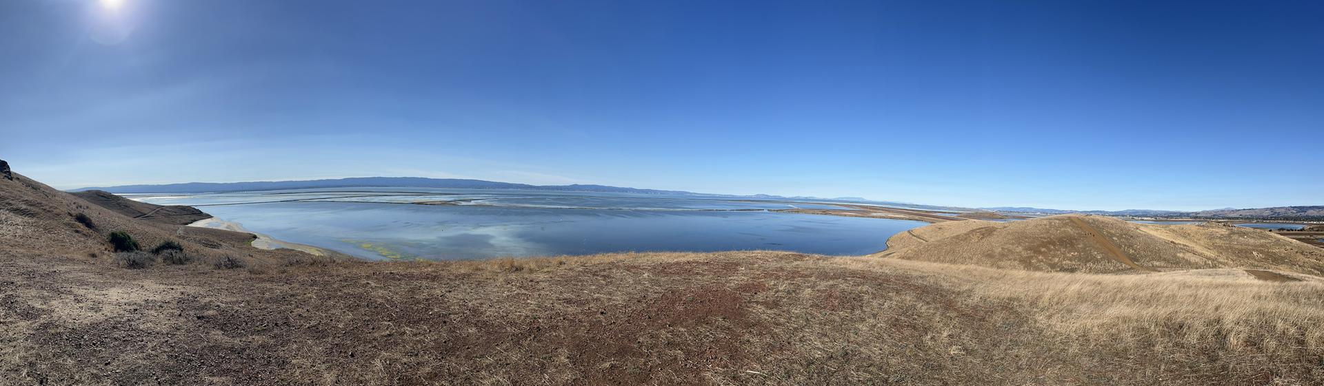 Panoramic view of a large body of water and distant hills.