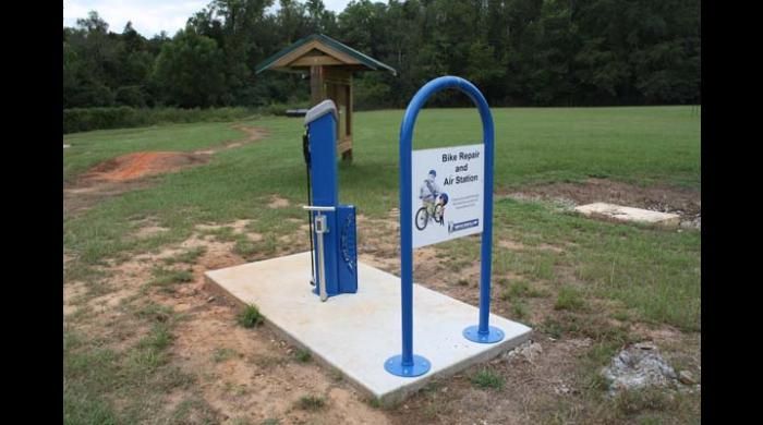 Blue bike repair and air station in a grassy field. - Forever Wild Trails