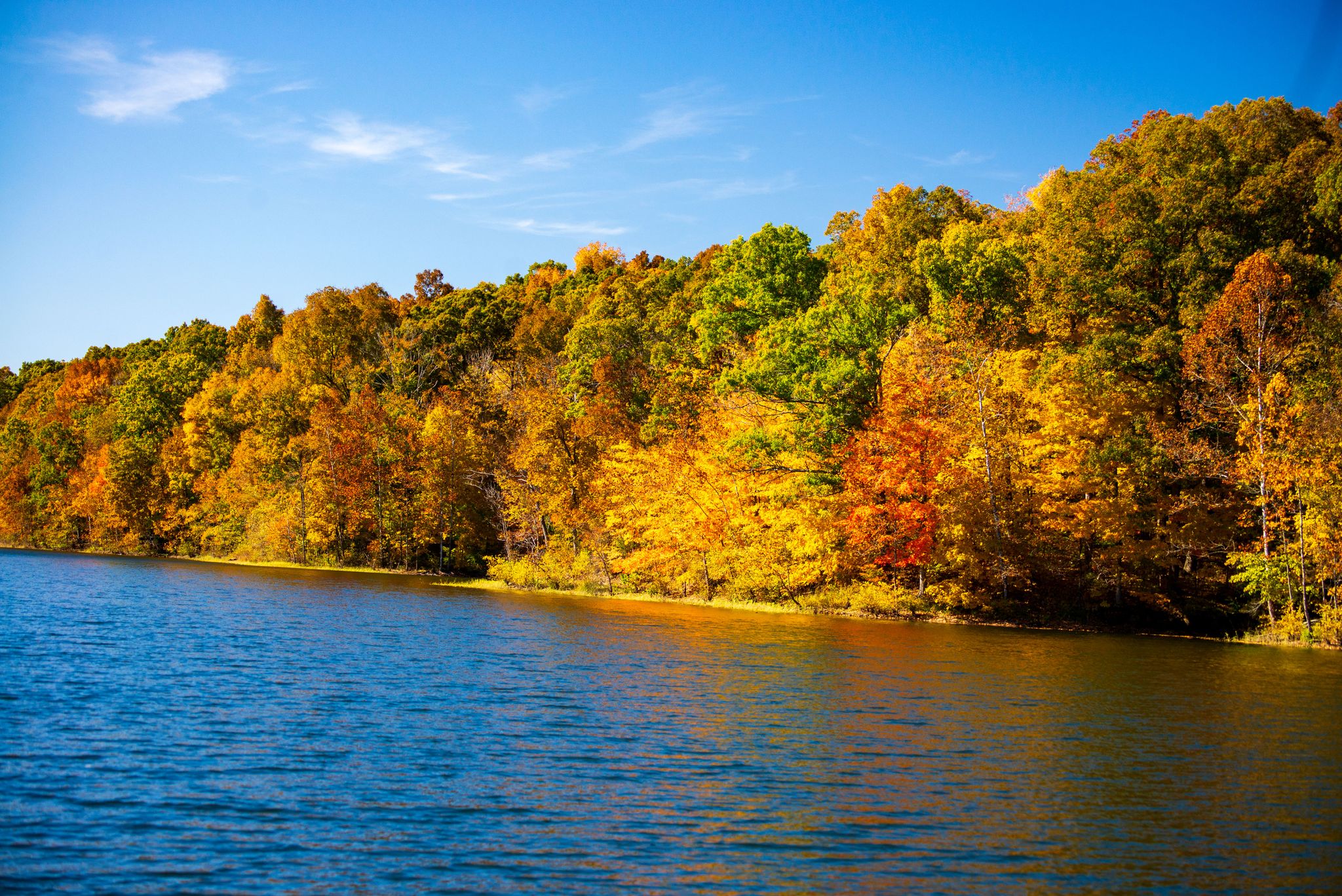 Blue lake reflecting vibrant autumn trees under a clear, sunny sky. - Two Lakes Loop Trail