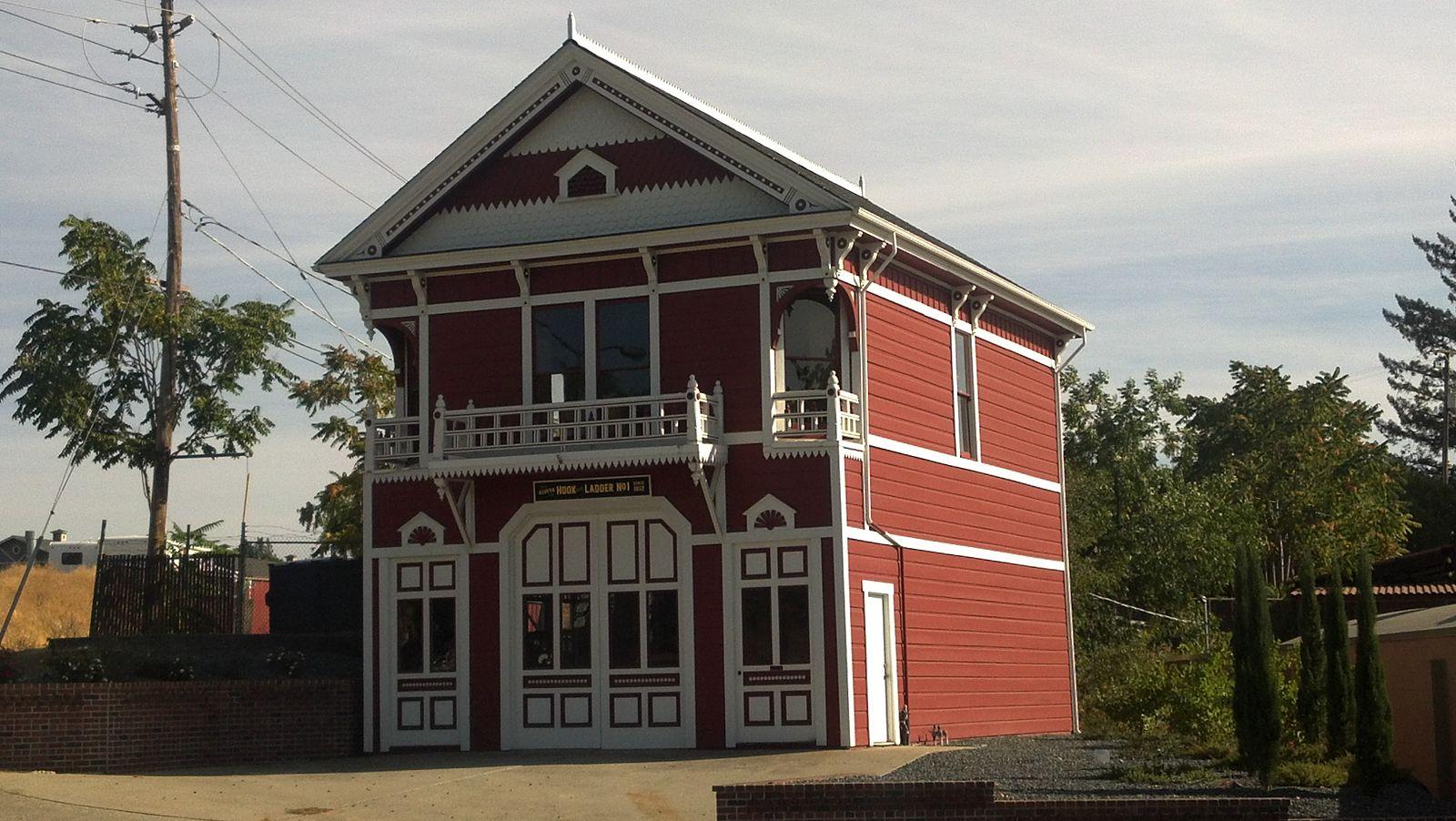 A bright red and white ornate two-story building under a clear sky.