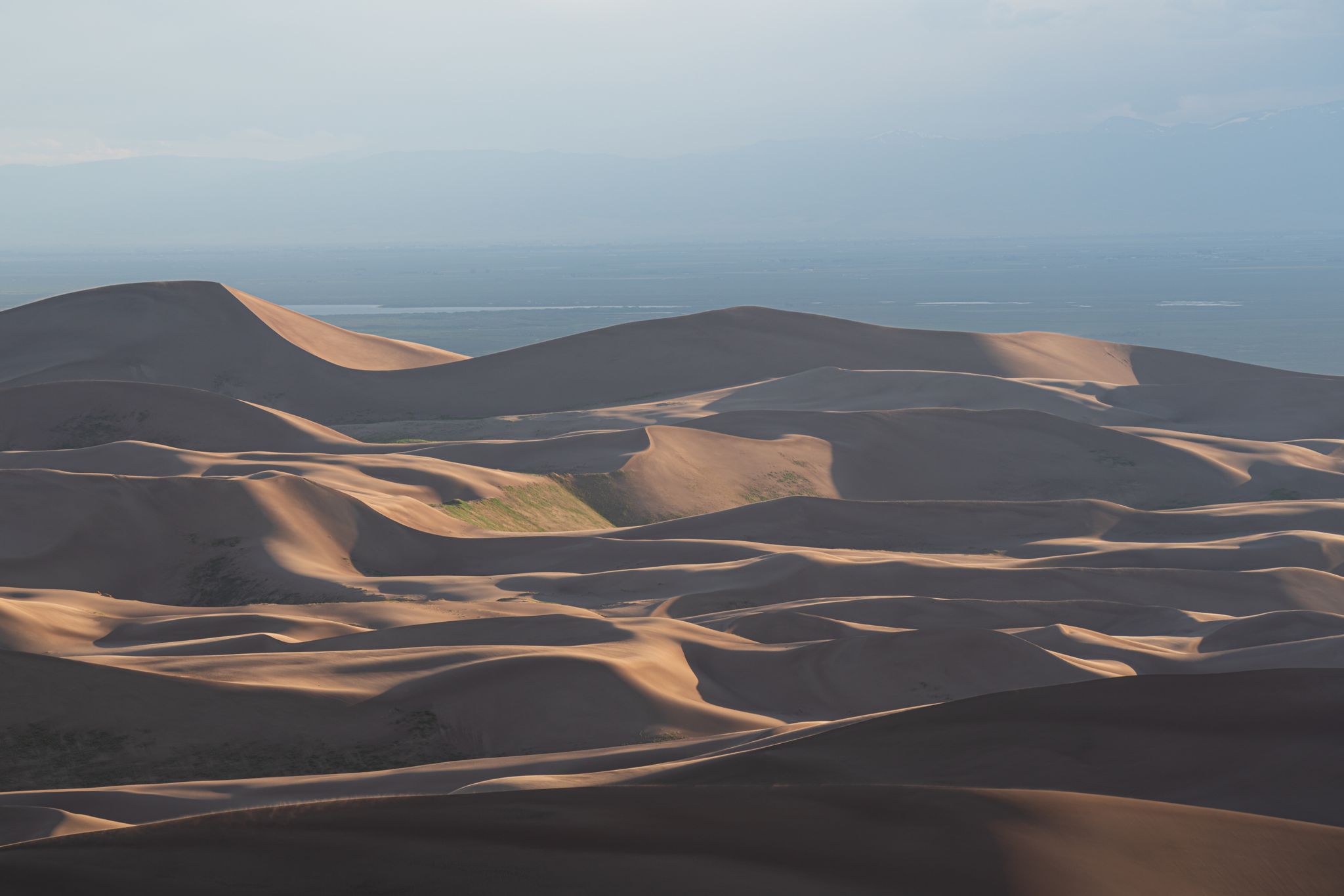 Sunlit sand dunes with long shadows stretching across a desert landscape. - Medano Pass Primitive Road