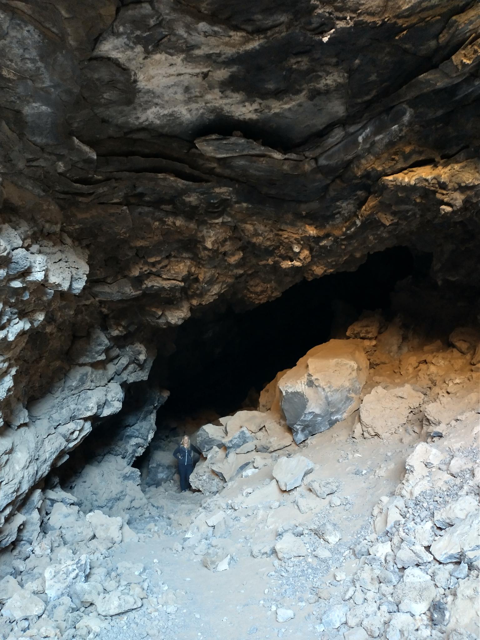 Dark, rocky cave entrance with a sandy floor.