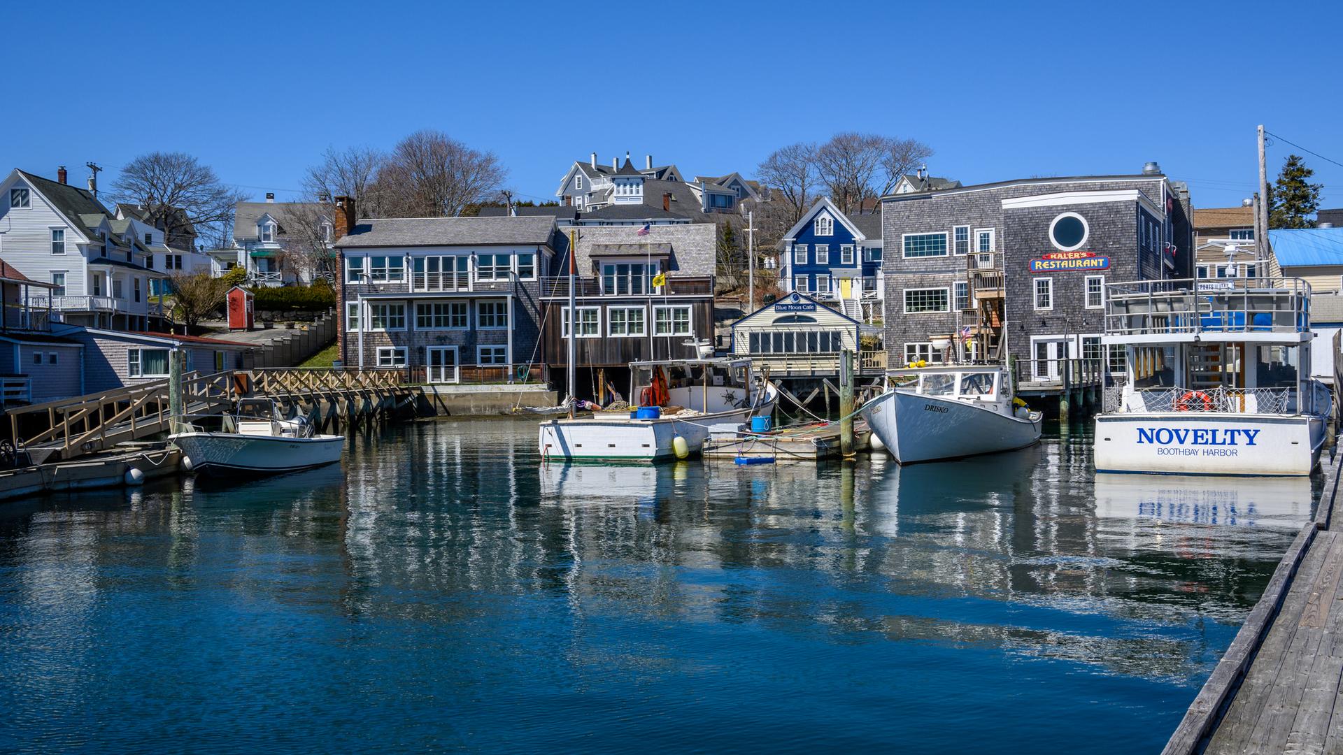 Vibrant harbor town with many boats docked on a bright sunny day.