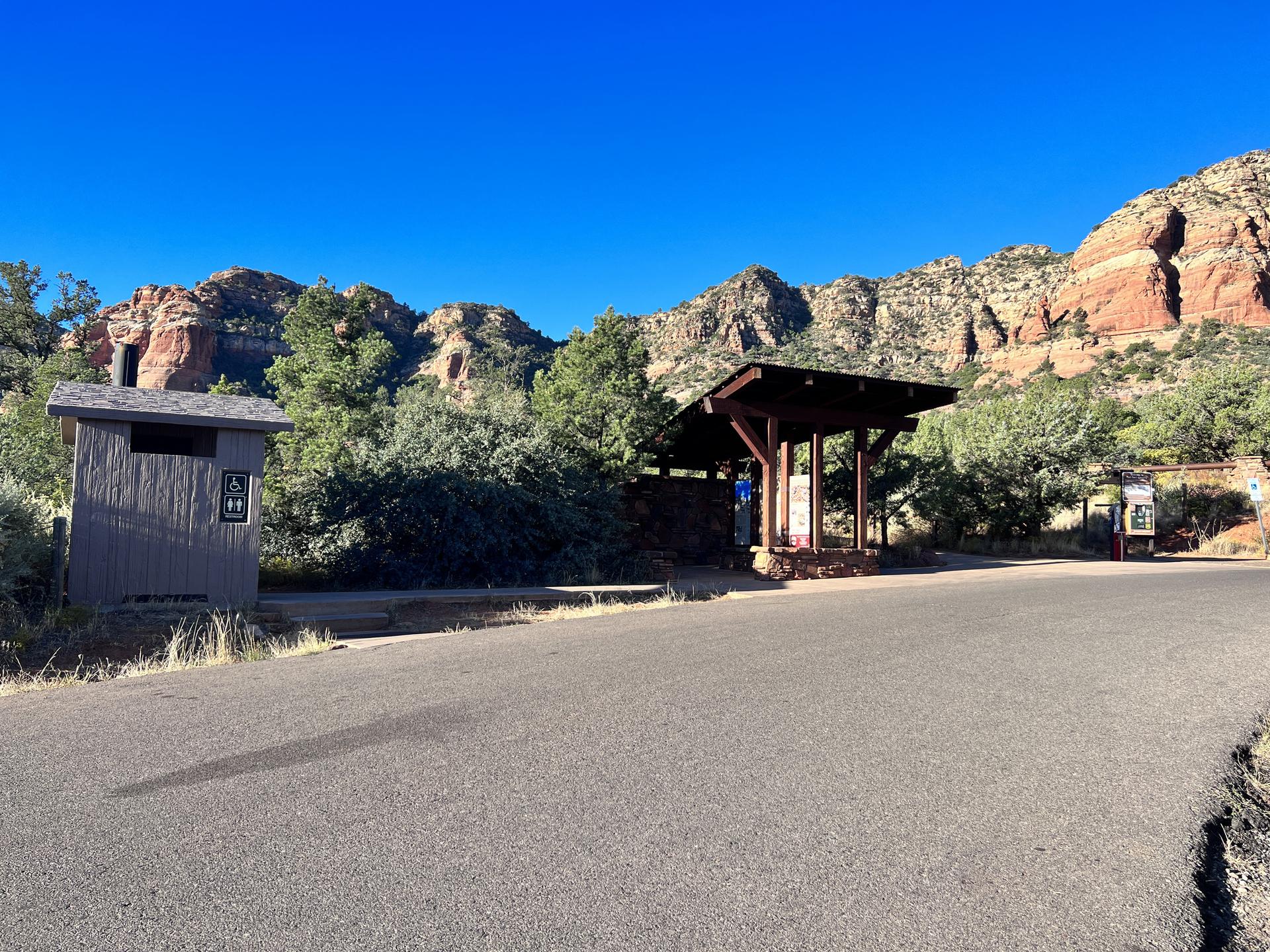 Restroom building and covered picnic area near red rock mountains.