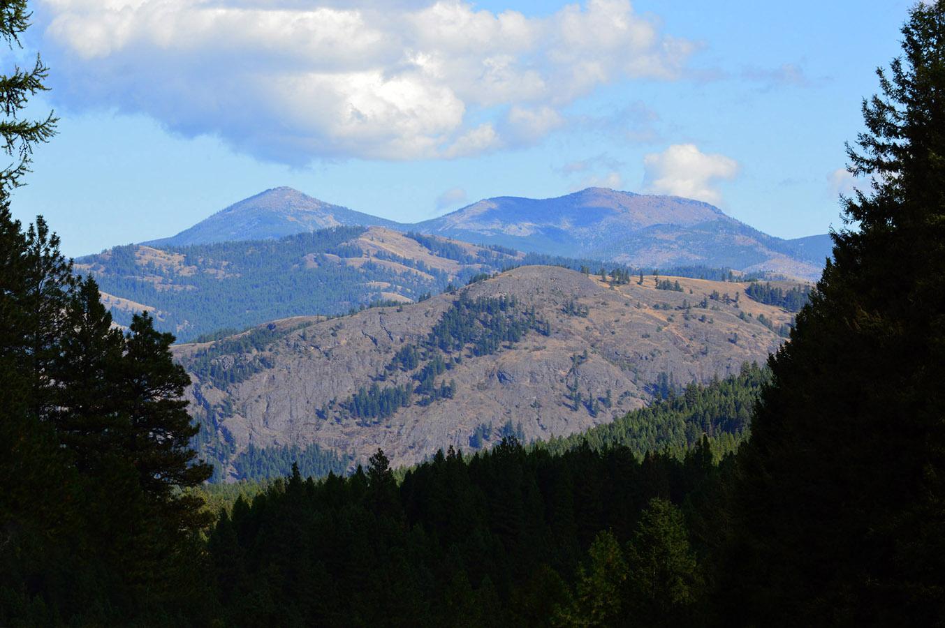 Distant mountains and forested hills under a partly cloudy sky.