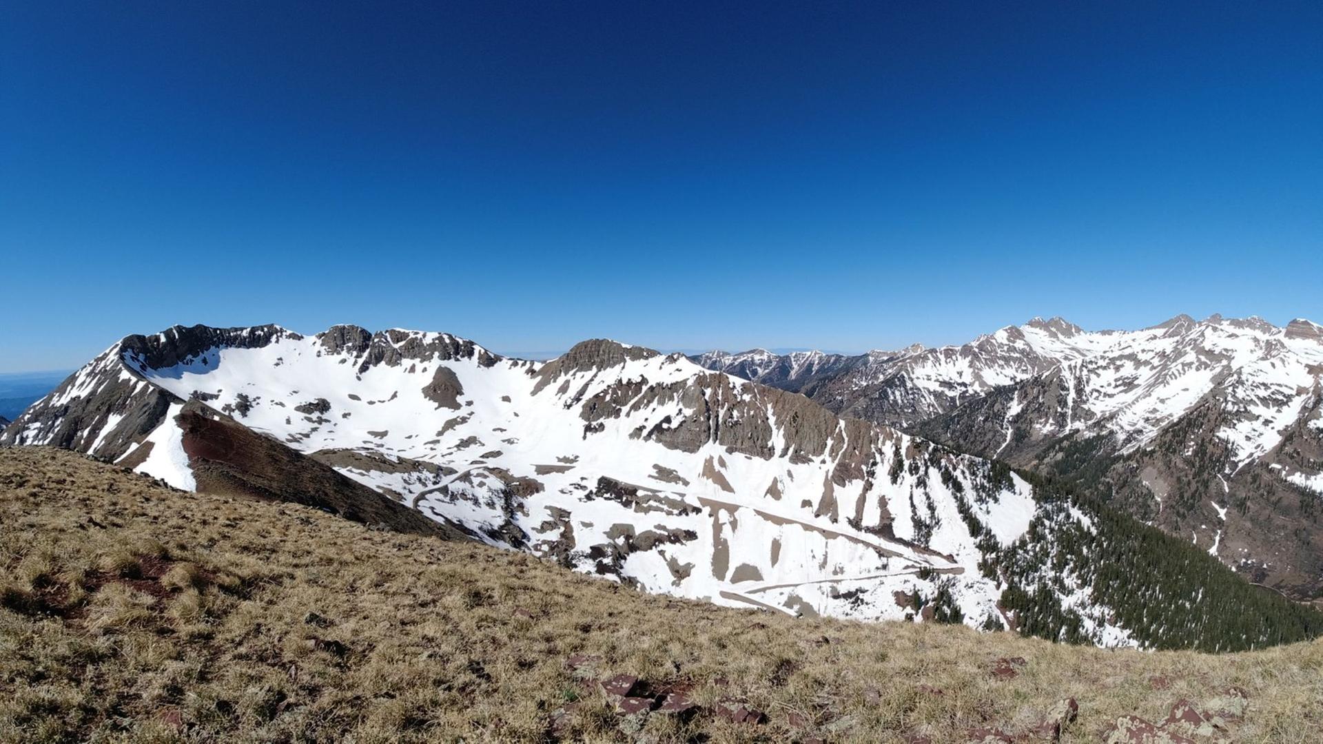 Panoramic view of vast snow-capped mountains under a clear blue sky.