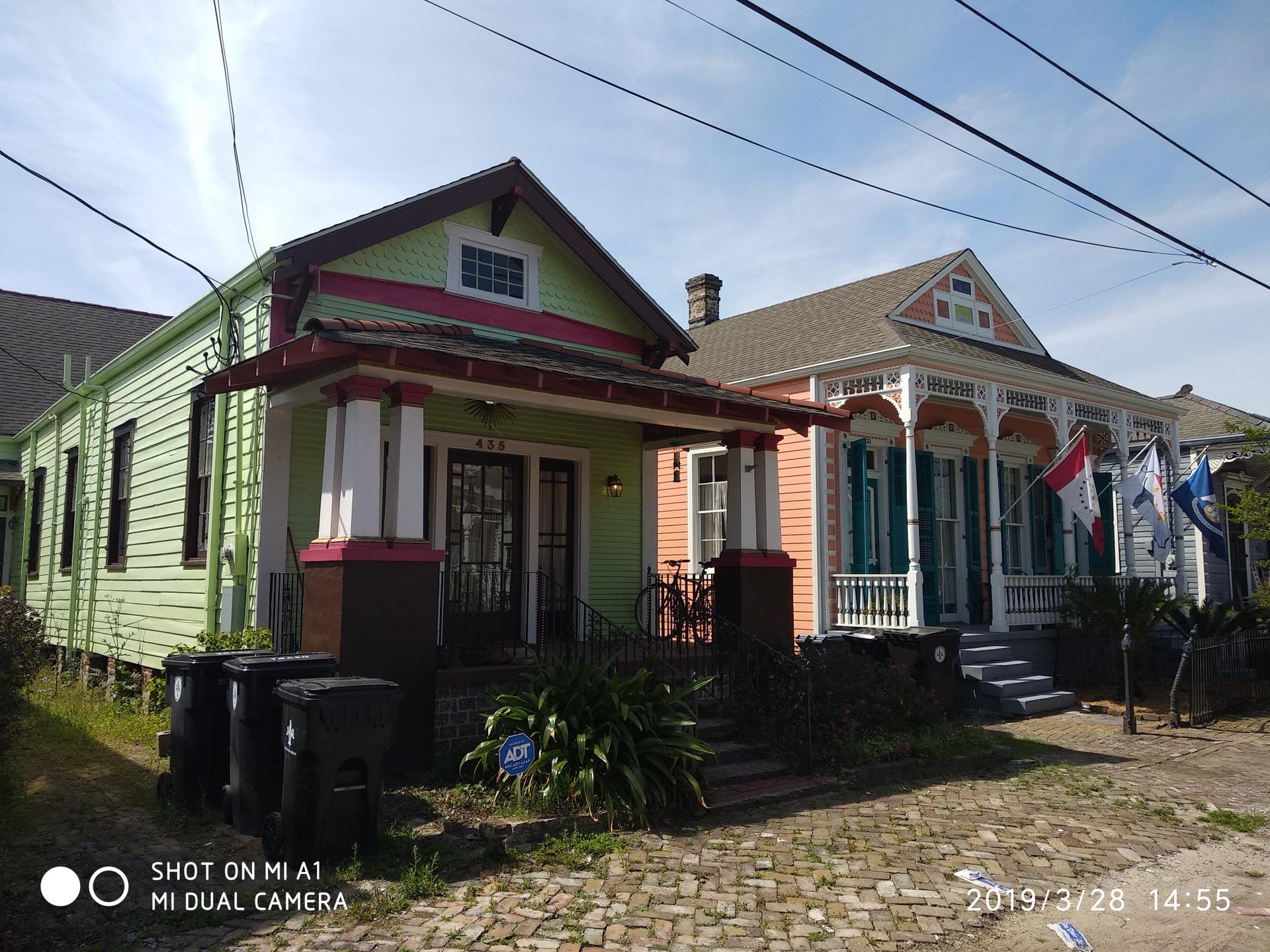 Two colorful houses with porches under a bright, sunny sky.