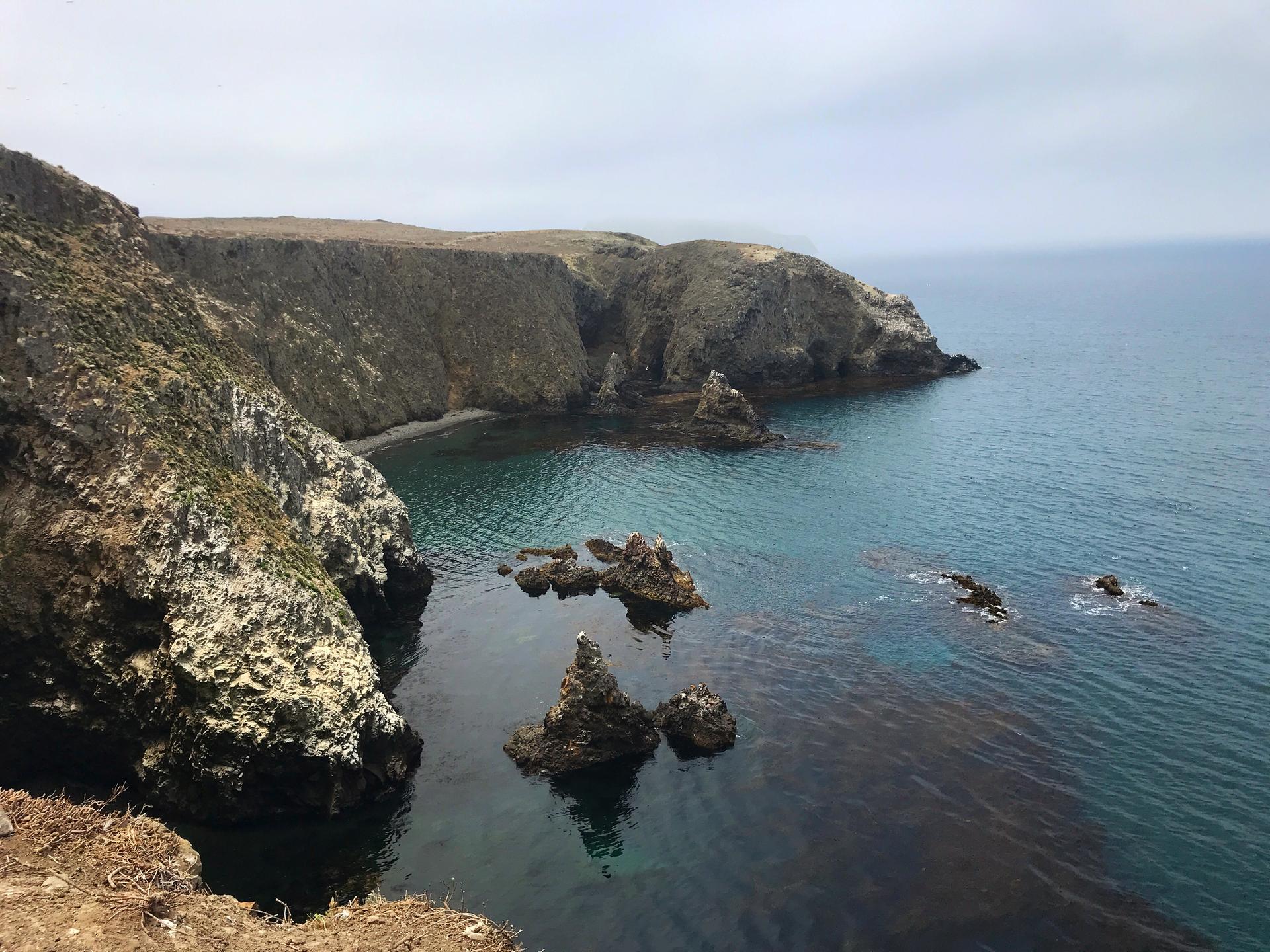 Rocky coastline with clear turquoise water and small rock formations.