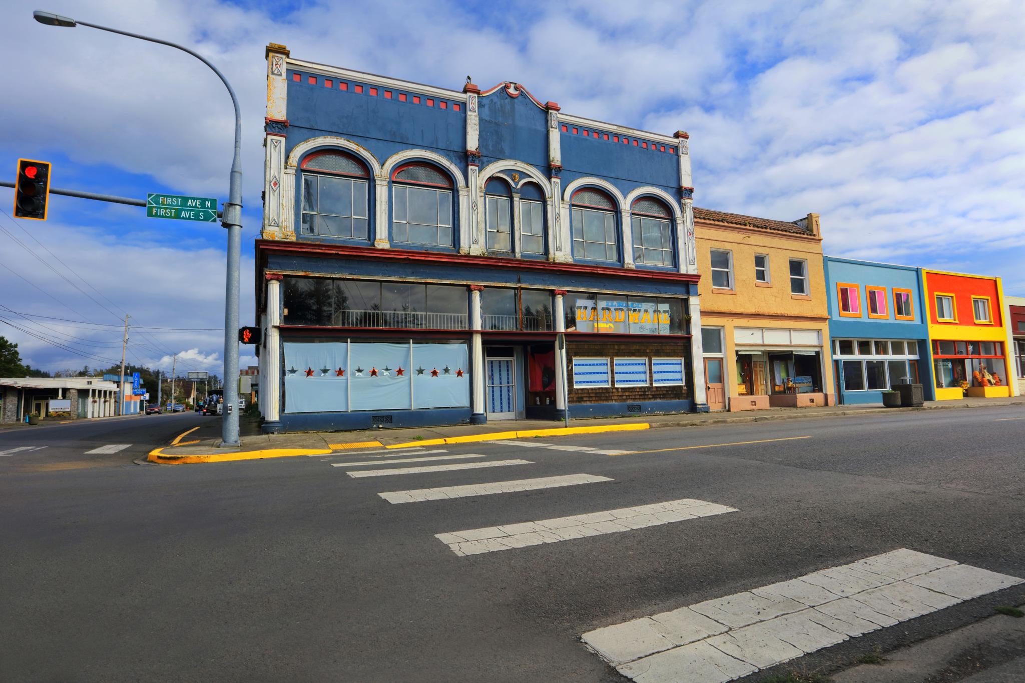 Colorful historic buildings on a street corner under a partly cloudy sky.