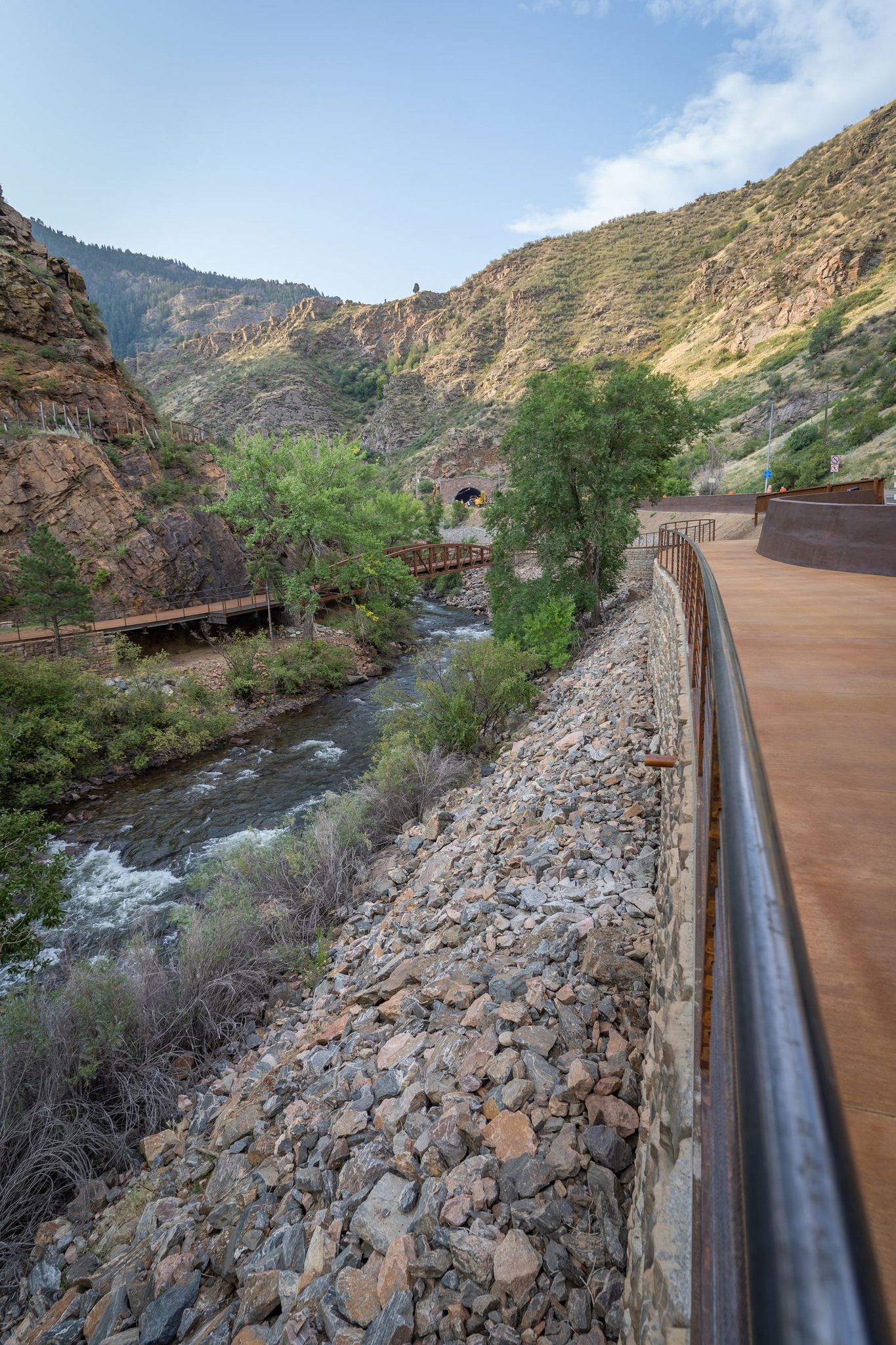 Elevated wooden walkway along a rocky mountain river under a clear sky. - Peaks to Plains and Welch Ditch Loop