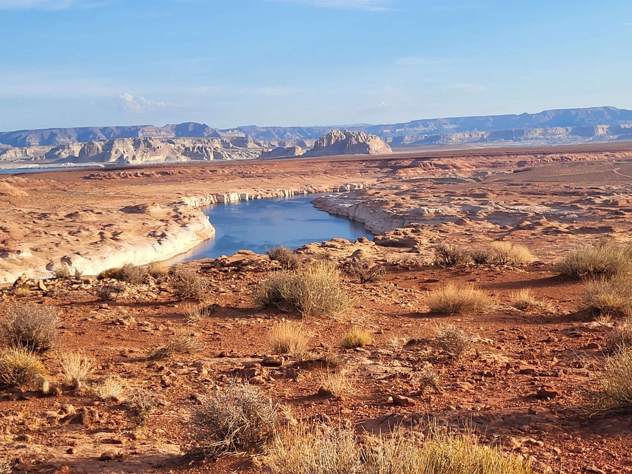 Blue lake winding through a vast red rock desert under a bright sky. - Grand View Overlook Park – Page Mesa Overlook loop from Page