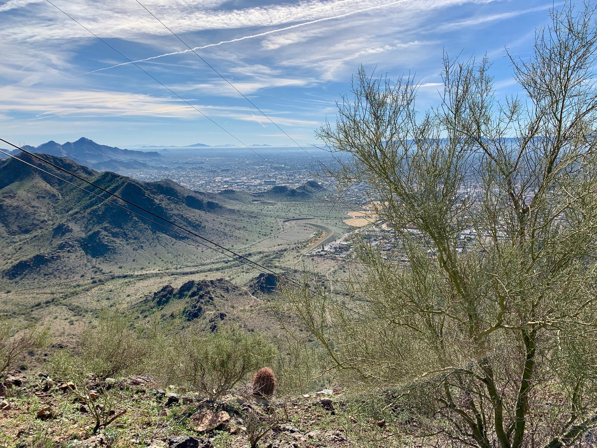Bright panoramic view of a desert valley, city, and mountains.