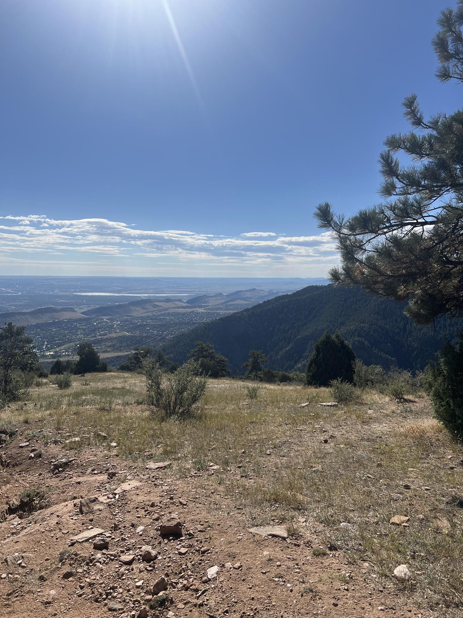 Sunny panoramic view from a hilltop overlooking a vast valley and plains. - Tower Trail