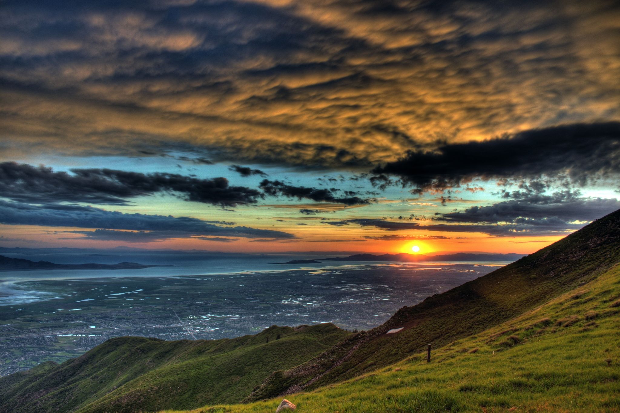 Dramatic sunset over green hills, a city, and distant water under colorful clouds. - Farmington – Farmington Pond loop from Farmington