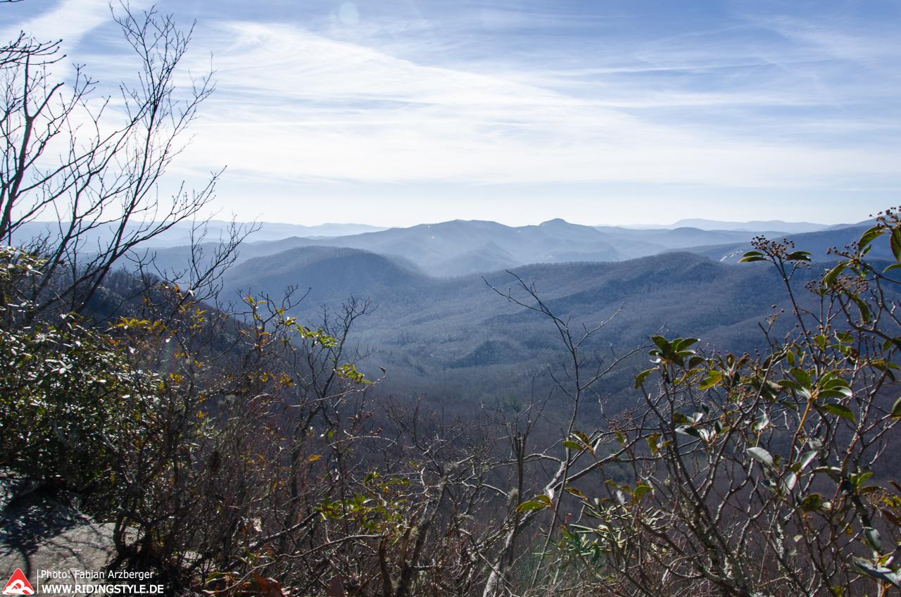 Panoramic view of distant hazy mountains under a partly cloudy sky.