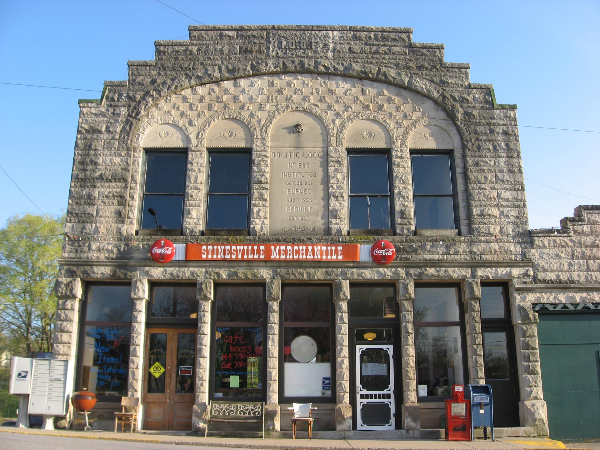 Historic stone mercantile building with multiple windows under a clear sky.