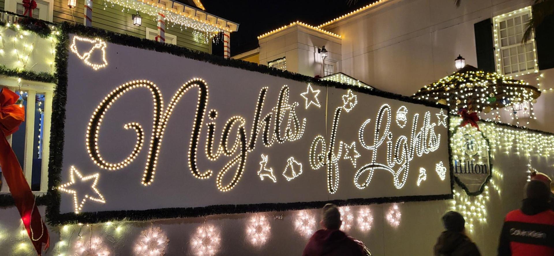 Bright "Nights of Lights" sign and festive decorations at night.