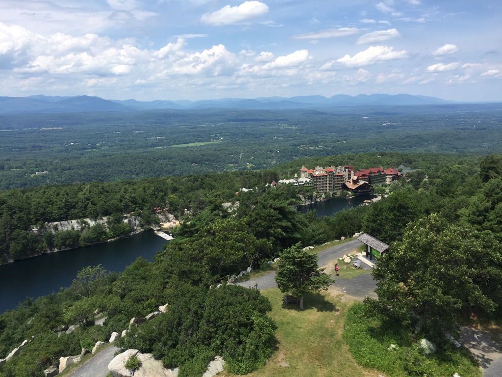 Aerial view of a large building by a lake surrounded by dense forest. - River-to-Ridge to Skytop Tower Loop