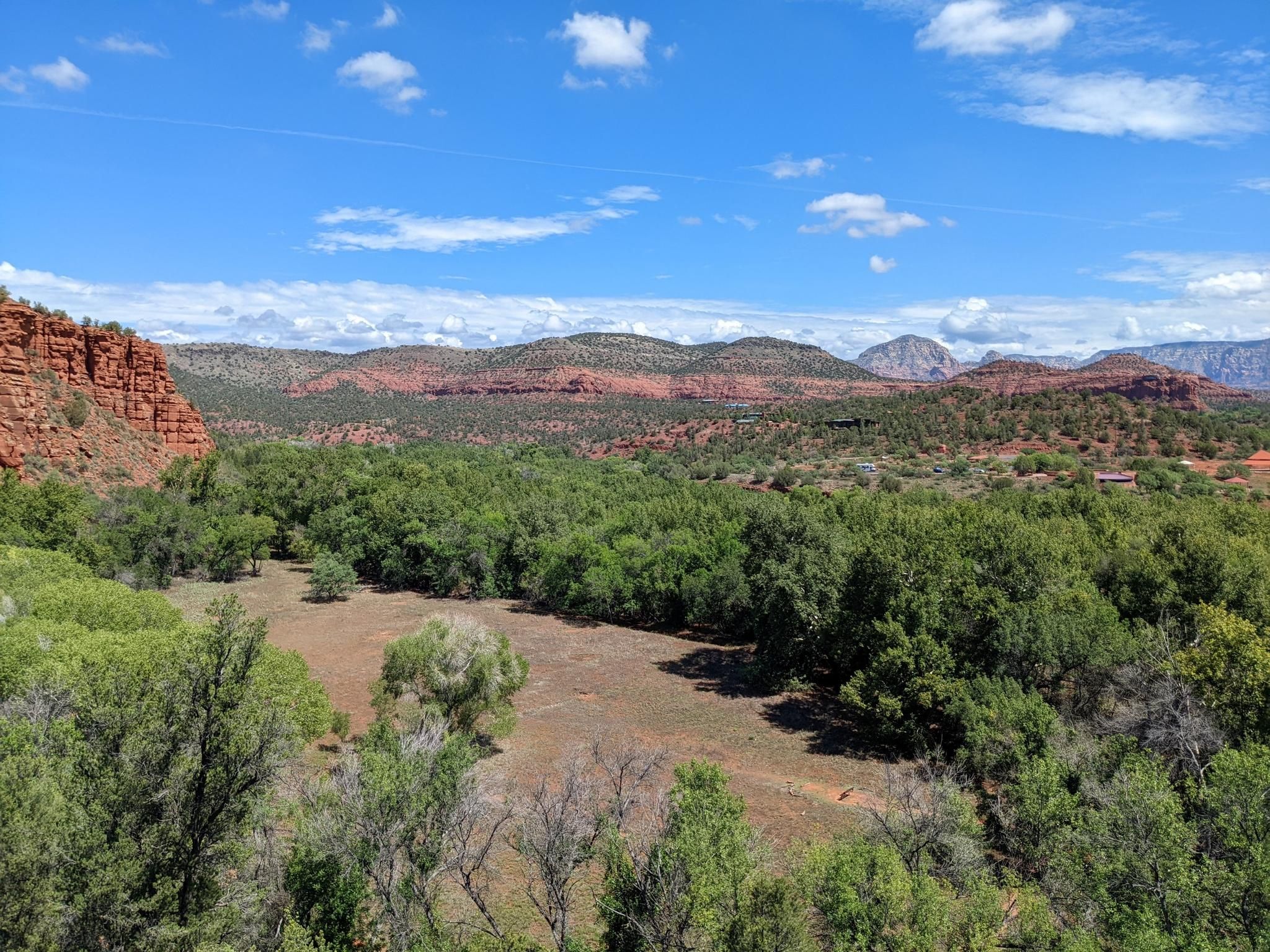 Panoramic view of a lush green valley surrounded by red rock formations. - Eagle's Nest and Kisva Trail Loop