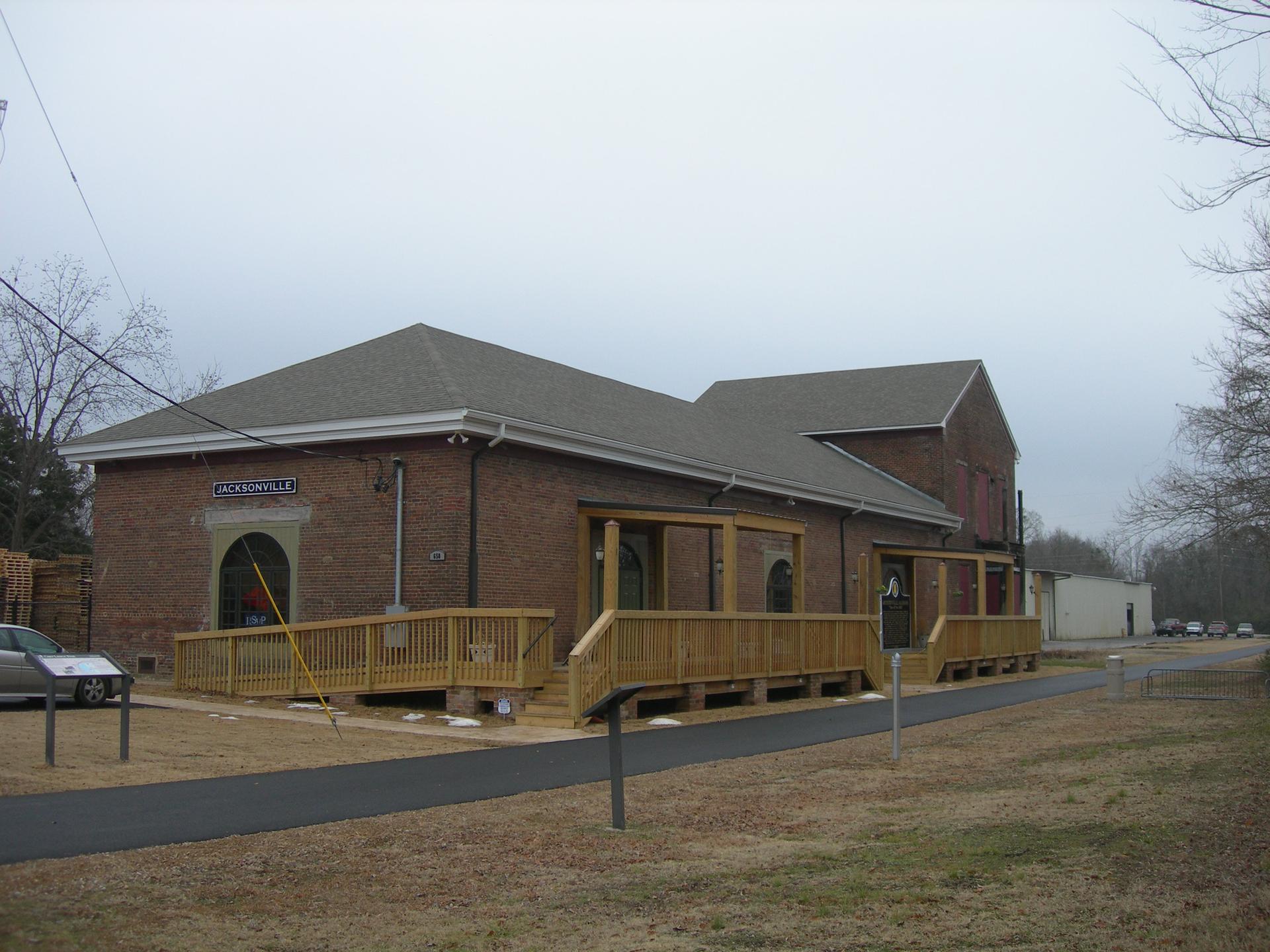 Brick building with wooden accessibility ramps under a cloudy, gray sky.