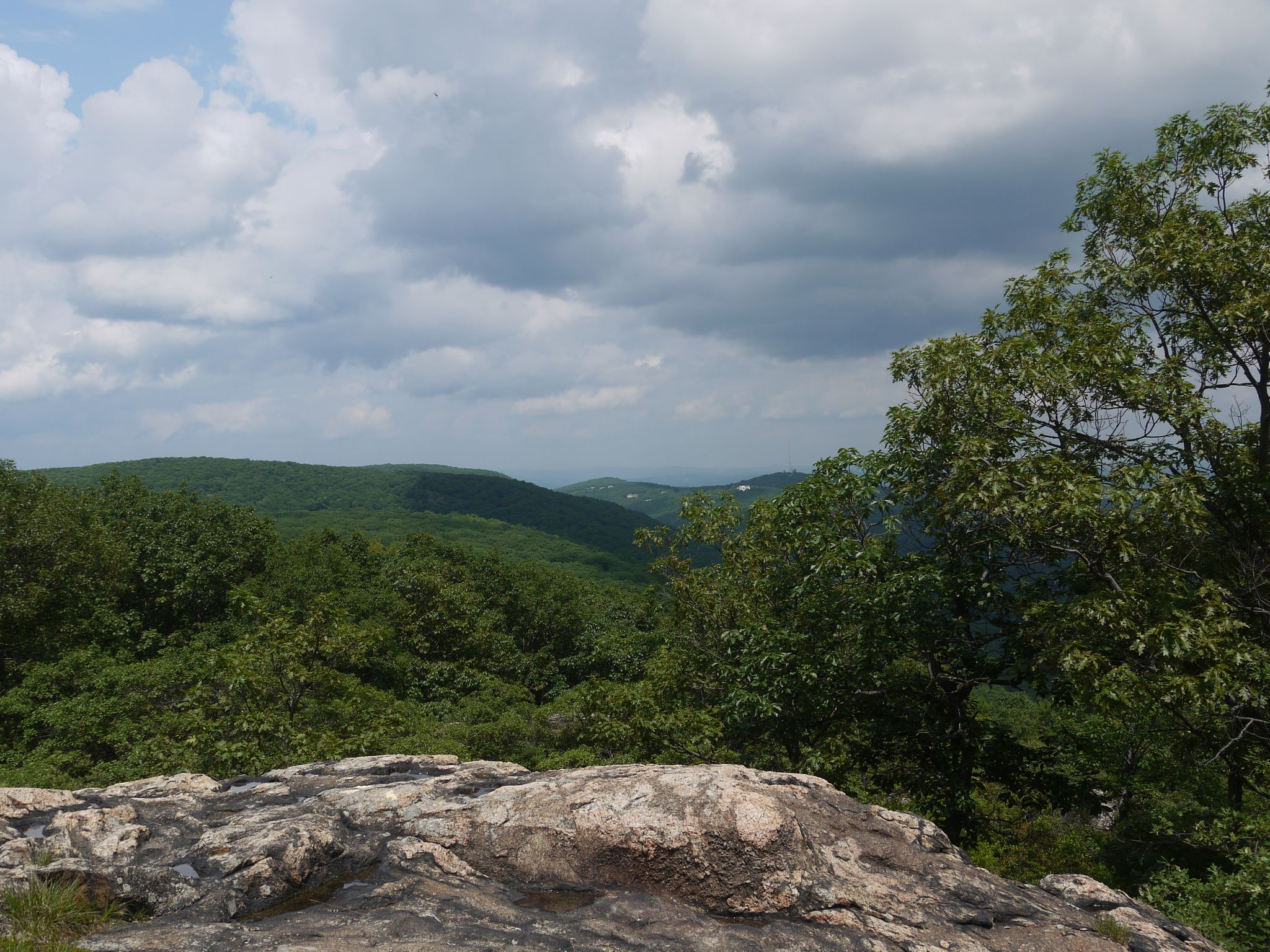 View of rolling green forested hills under a cloudy sky from a rocky outcrop. - Wesley Hills to Panther Mountain via Pine Meadow Trail loop