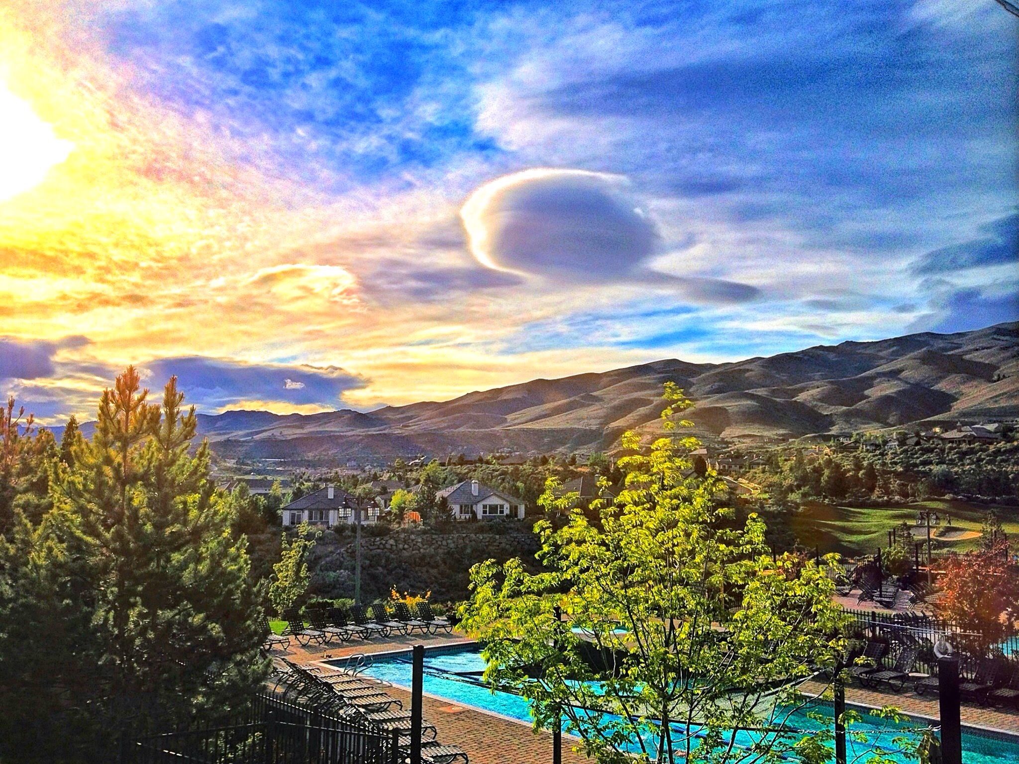 Dramatic sunset over mountains, a pool, and houses, with vibrant clouds. - Somersett & Verdi loop