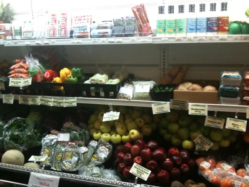 Shelves filled with various fresh produce and packaged goods in a store.